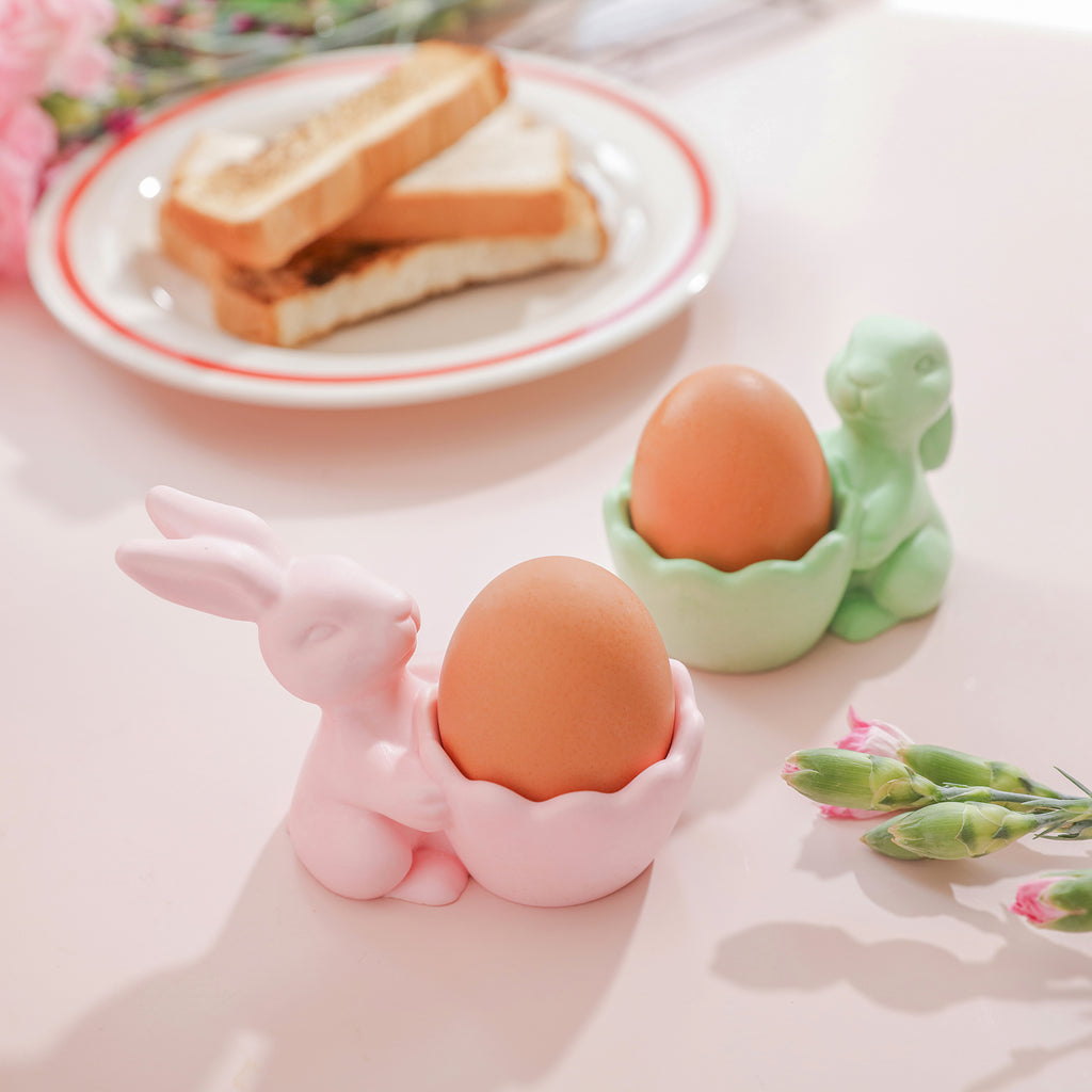 Two rabbit egg cups hold an egg each