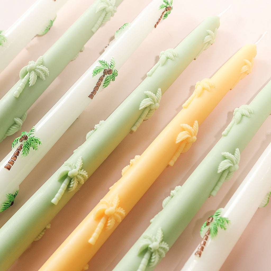 Palm tree embossed taper candles in different colors made with silicone molds.