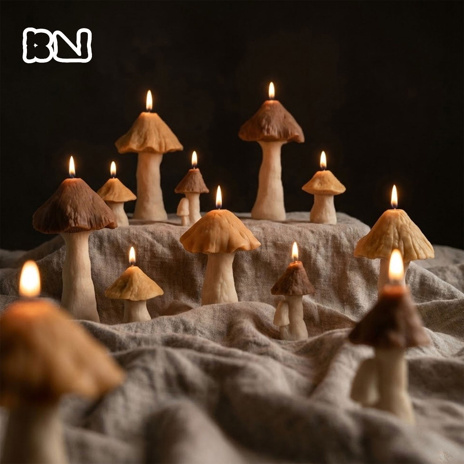 A collection of various sized mushroom-shaped candles in earthy brown tones, burning on a textured linen cloth for a cozy forest-themed decor - Boowan Nicole