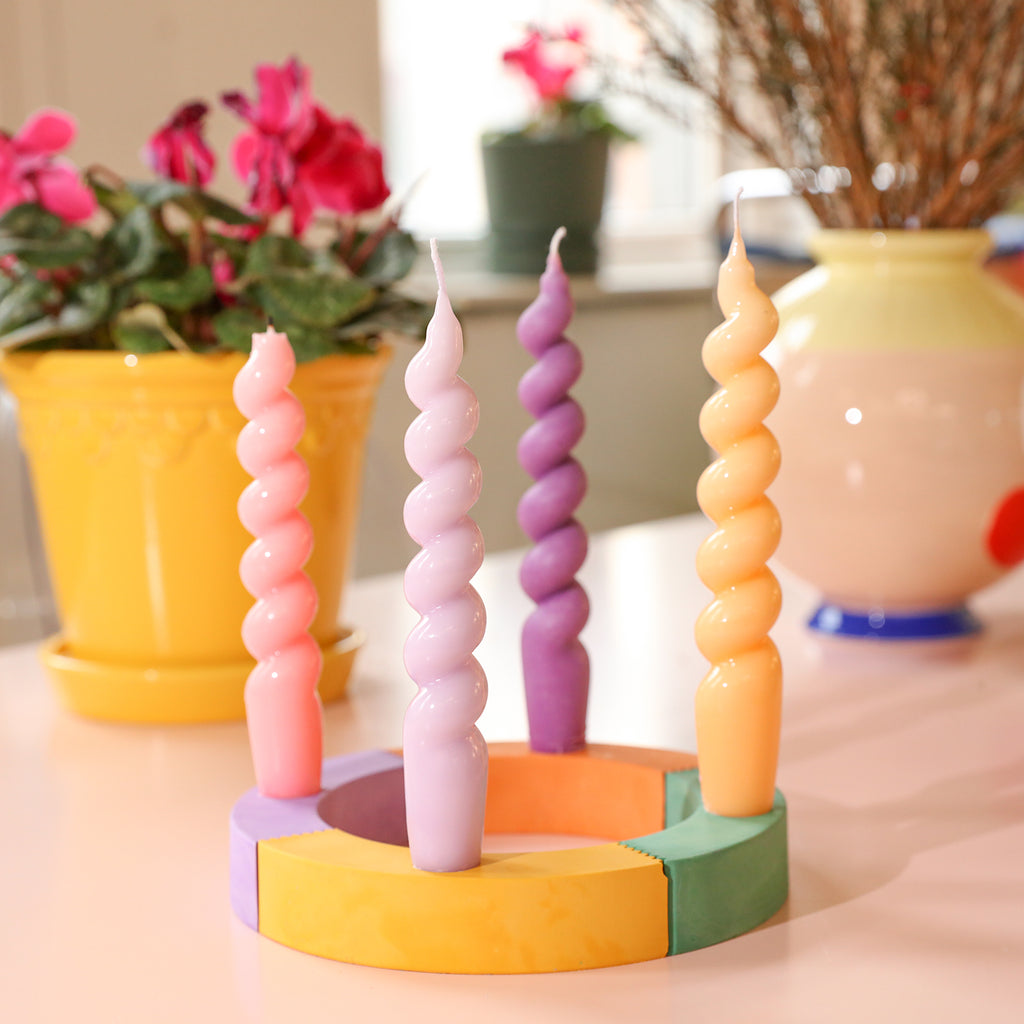Four taper candles elegantly arranged on a candle holder crafted from Boowannite material.