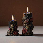 Two sizes lit Venom & Roses gothic pillar candles with skull, coiled serpent and red rose relief minimalist neutral studio shot - Boowan Nicole