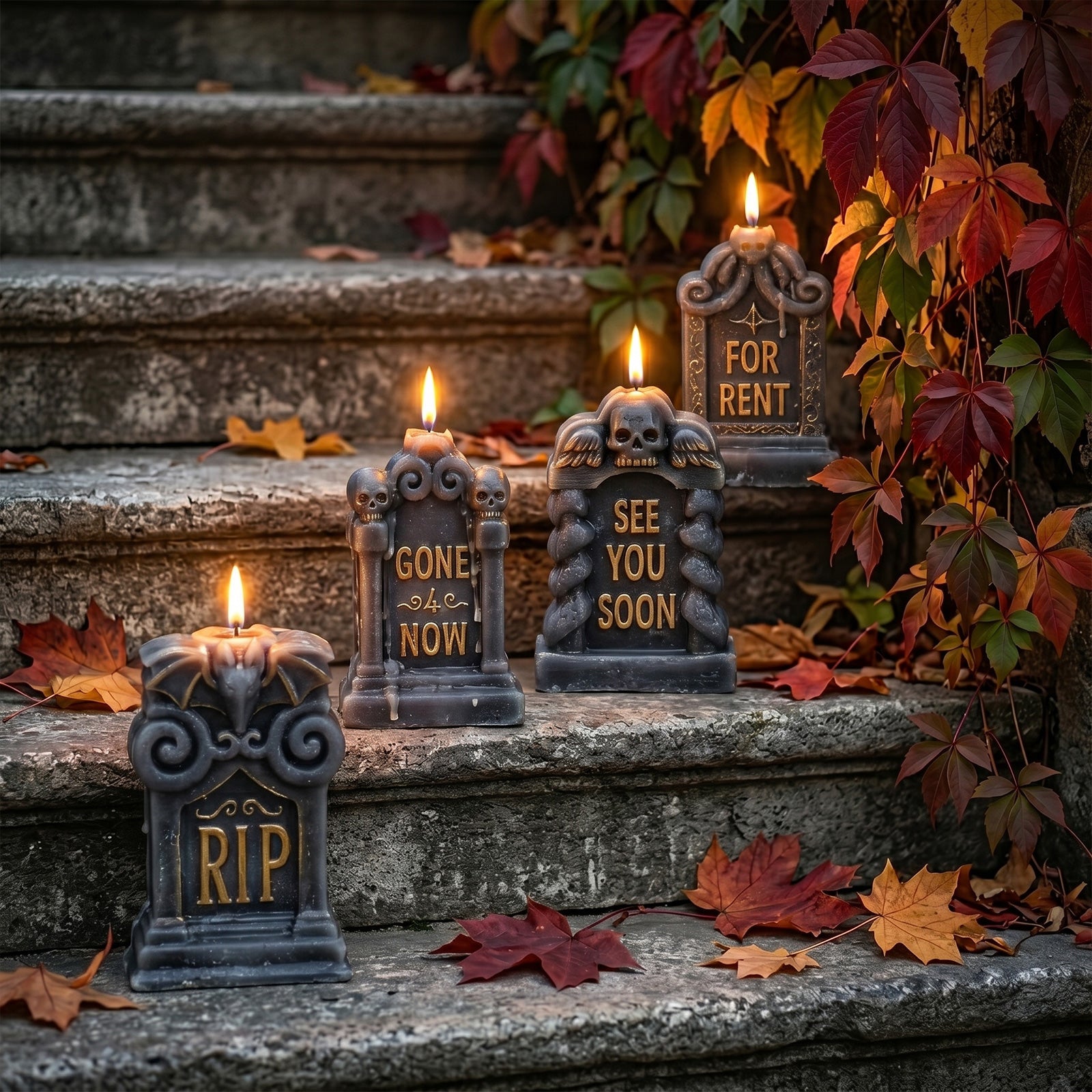 Four lit gothic tombstone candles arranged on vintage stone steps with autumn maple leaves spooky outdoor Halloween styling - Boowan Nicole