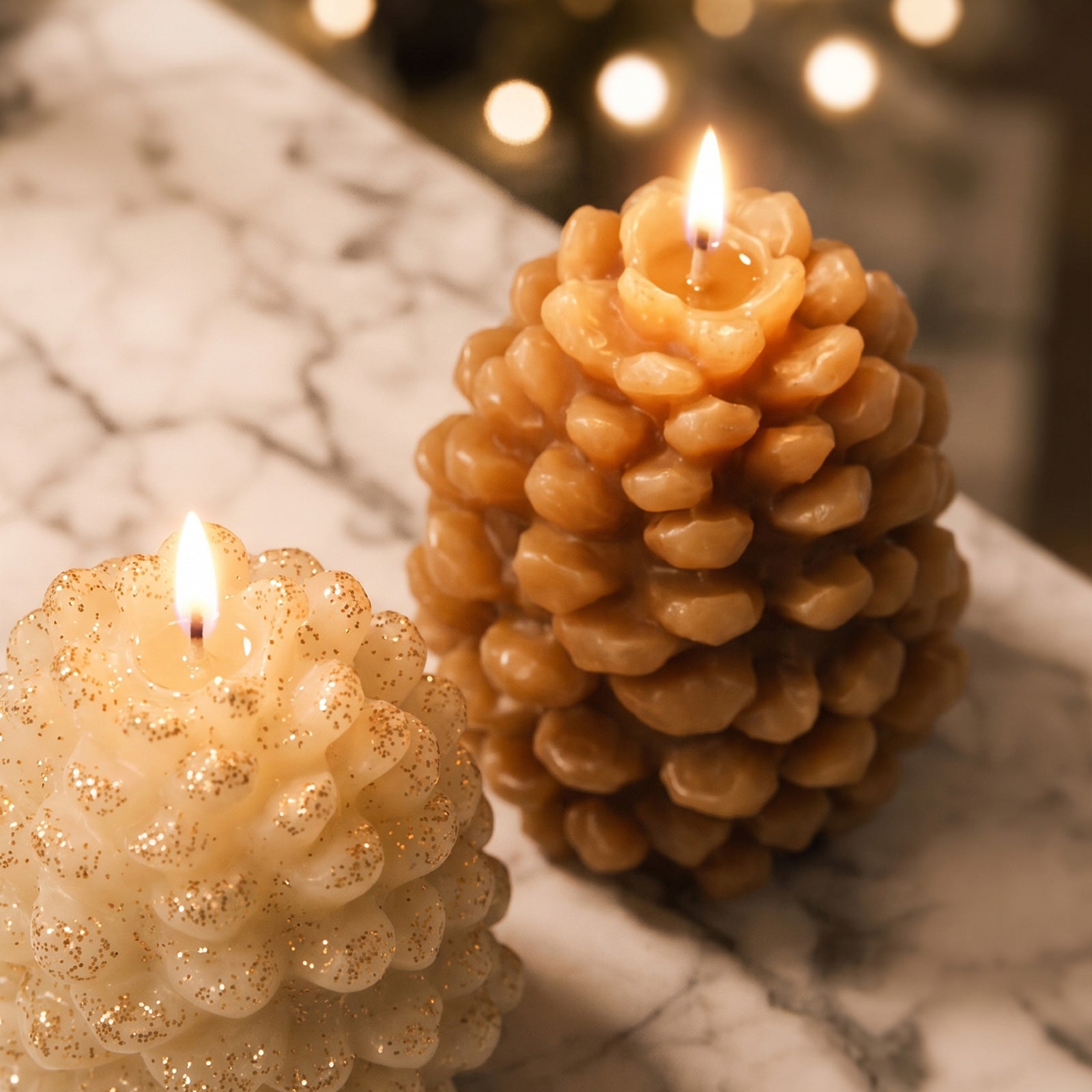 Close-up of glowing cream and caramel textured winter pinecone candles on marble table seasonal home decor shot - Boowan Nicole