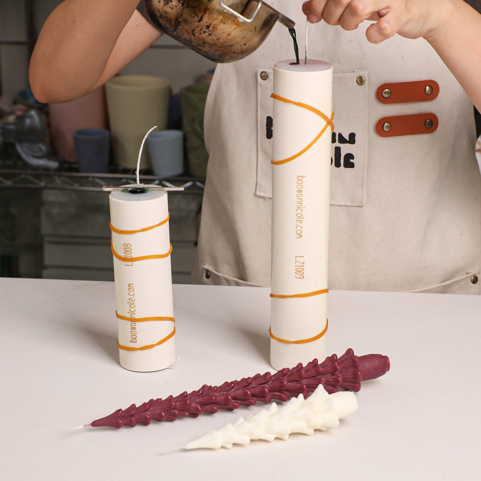 Pouring melted wax into Winter Pine Taper Candle silicone mold during candle‑making process - Boowan Nicole