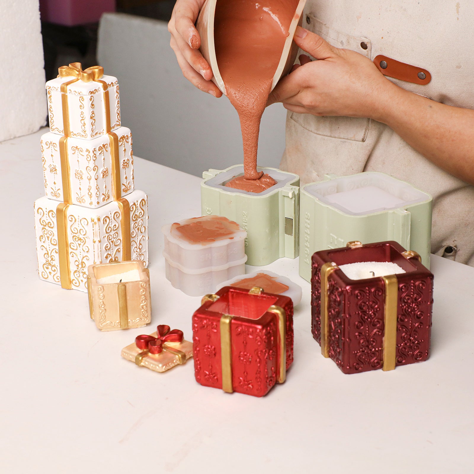 Pouring raw material into stacked Christmas gift box candle jar silicone molds DIY craft - Boowan Nicole