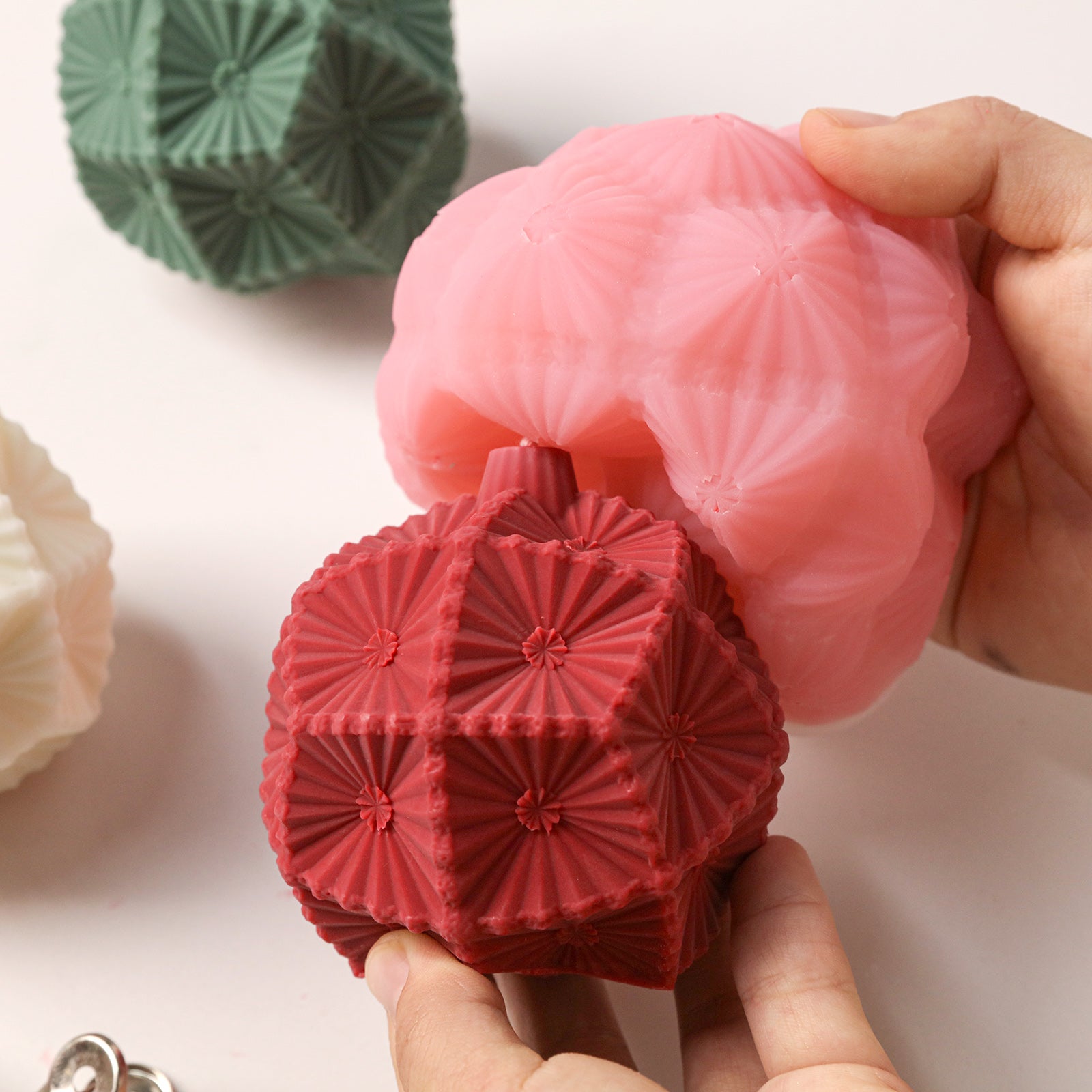 Demolding finished red textured ornament ball candle from flexible silicone mold - Boowan Nicole