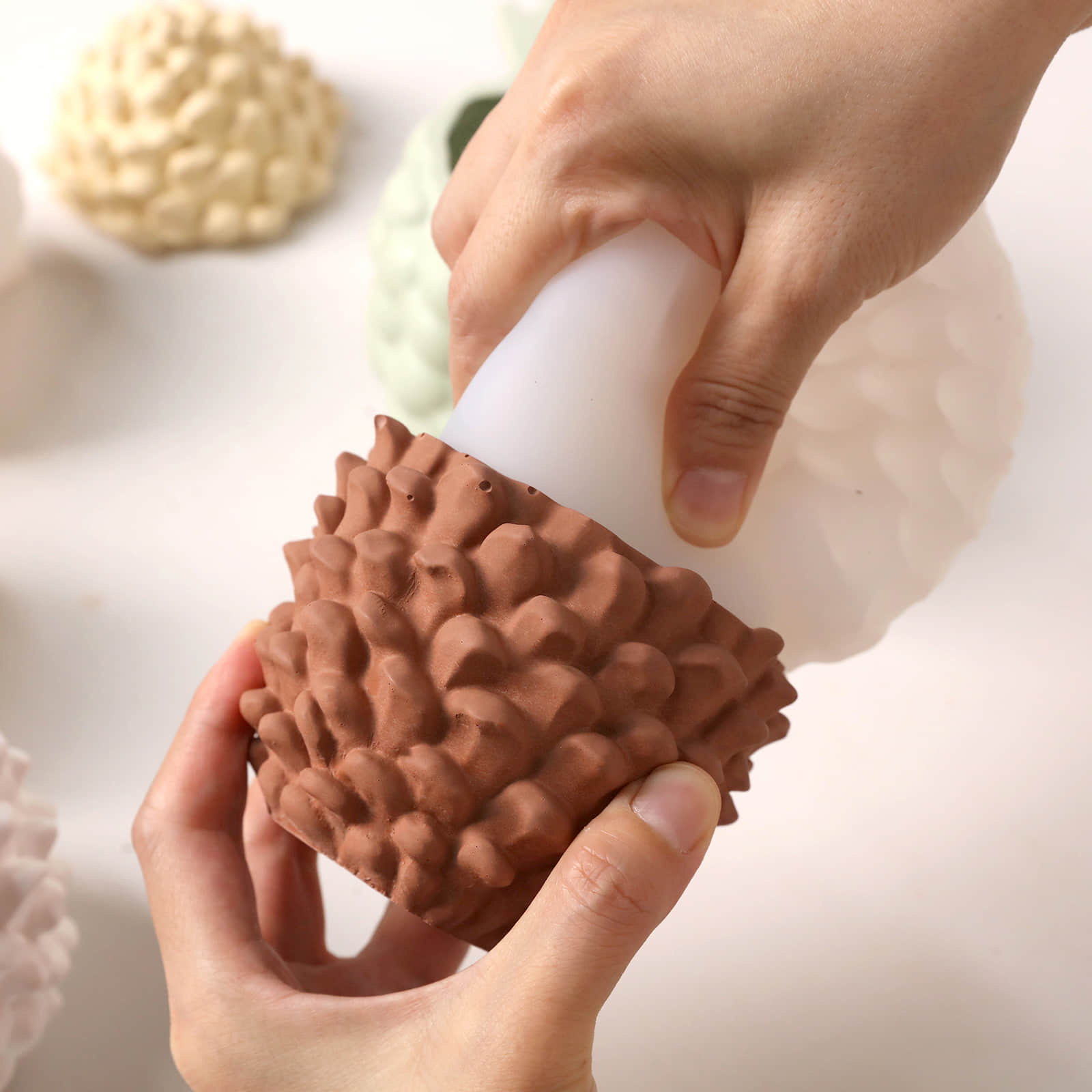 Demolding terracotta Little Woodland Pinecone candle jar blank from flexible silicone handmade mold workshop shot - Boowan Nicole