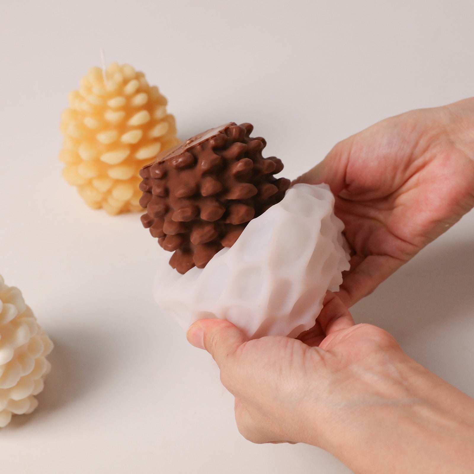 Demolding dark brown winter pinecone candle blank from flexible silicone mold DIY handmade workshop shot - Boowan Nicole