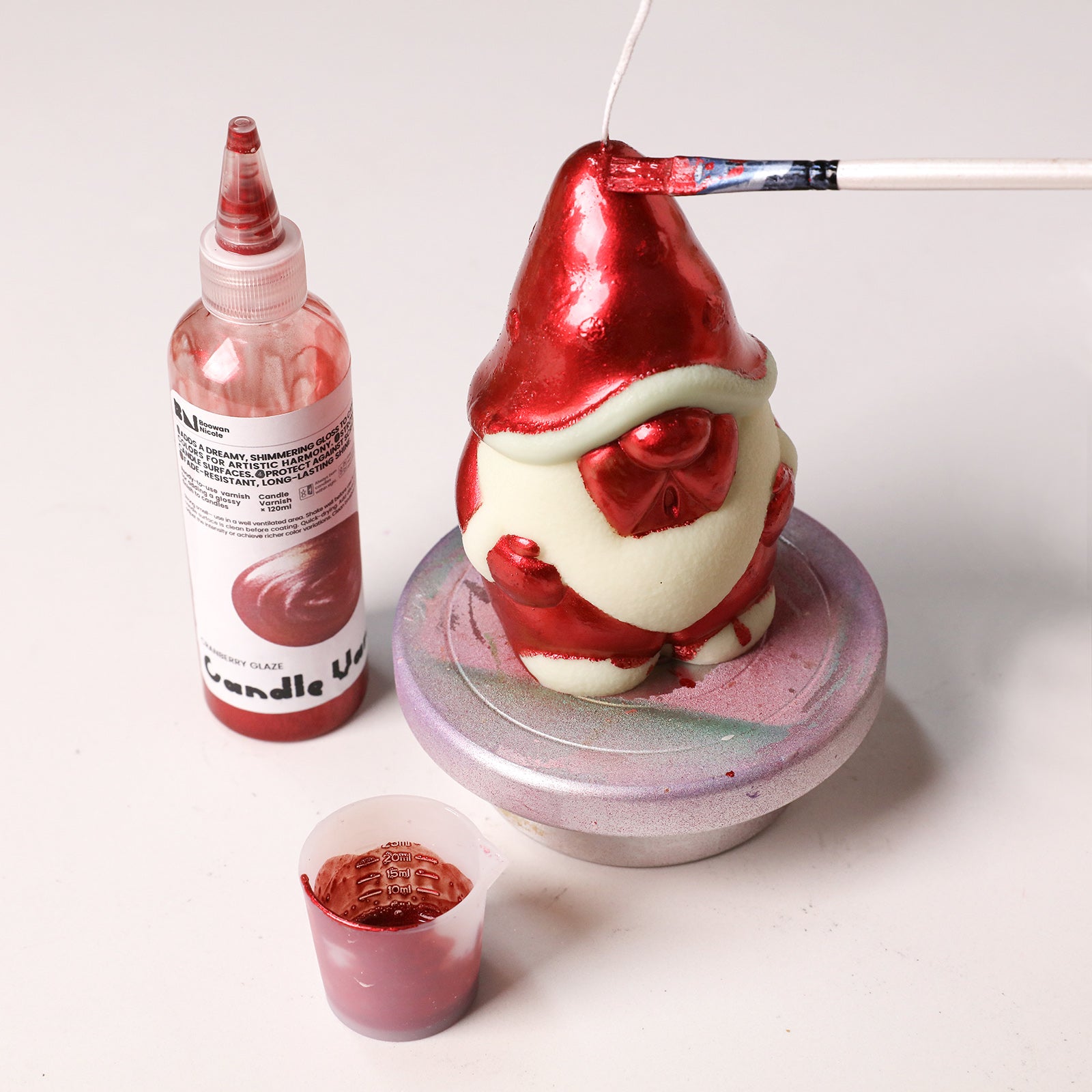 Hand painting red metallic glaze onto handmade gnome candle craft piece - Boowan Nicole