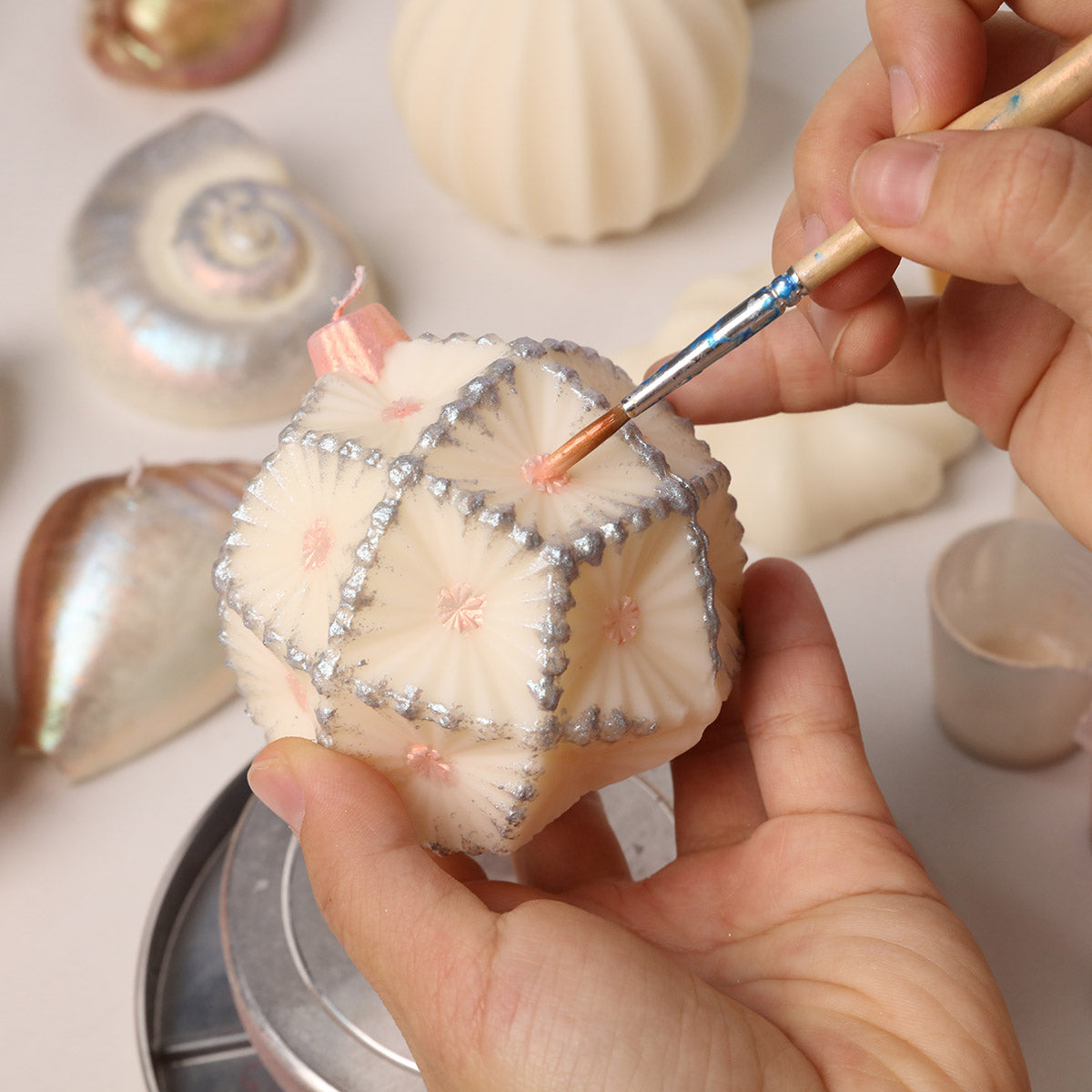 Hand Adding Silver Pearl Varnish Details on Geometric Embossed Sphere Candle - Boowan Nicole