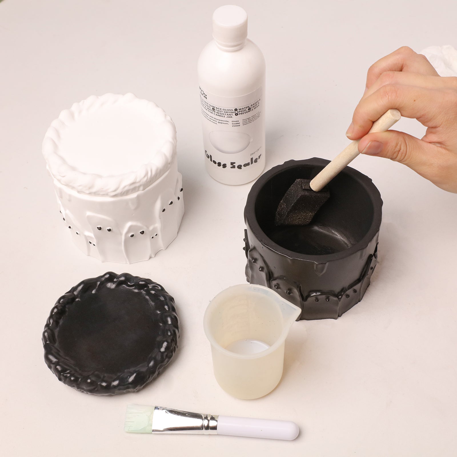 DIY crafting supplies including ghost cake candle jar blank, gloss sealer, mixing cup and painting brush - Boowan Nicole