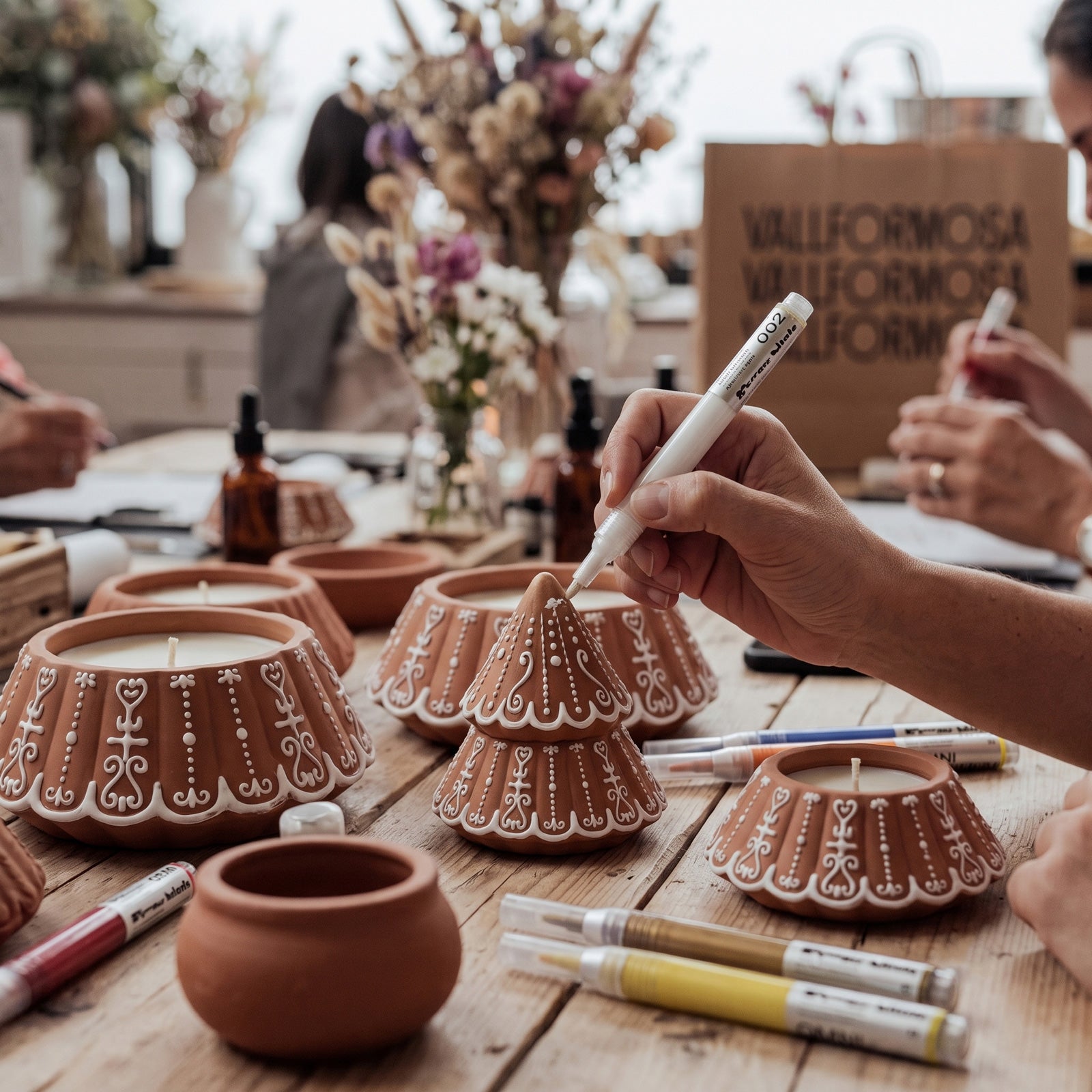 DIY craft workshop hand drawing decorative details on gingerbread tree candle jars - Boowan Nicole