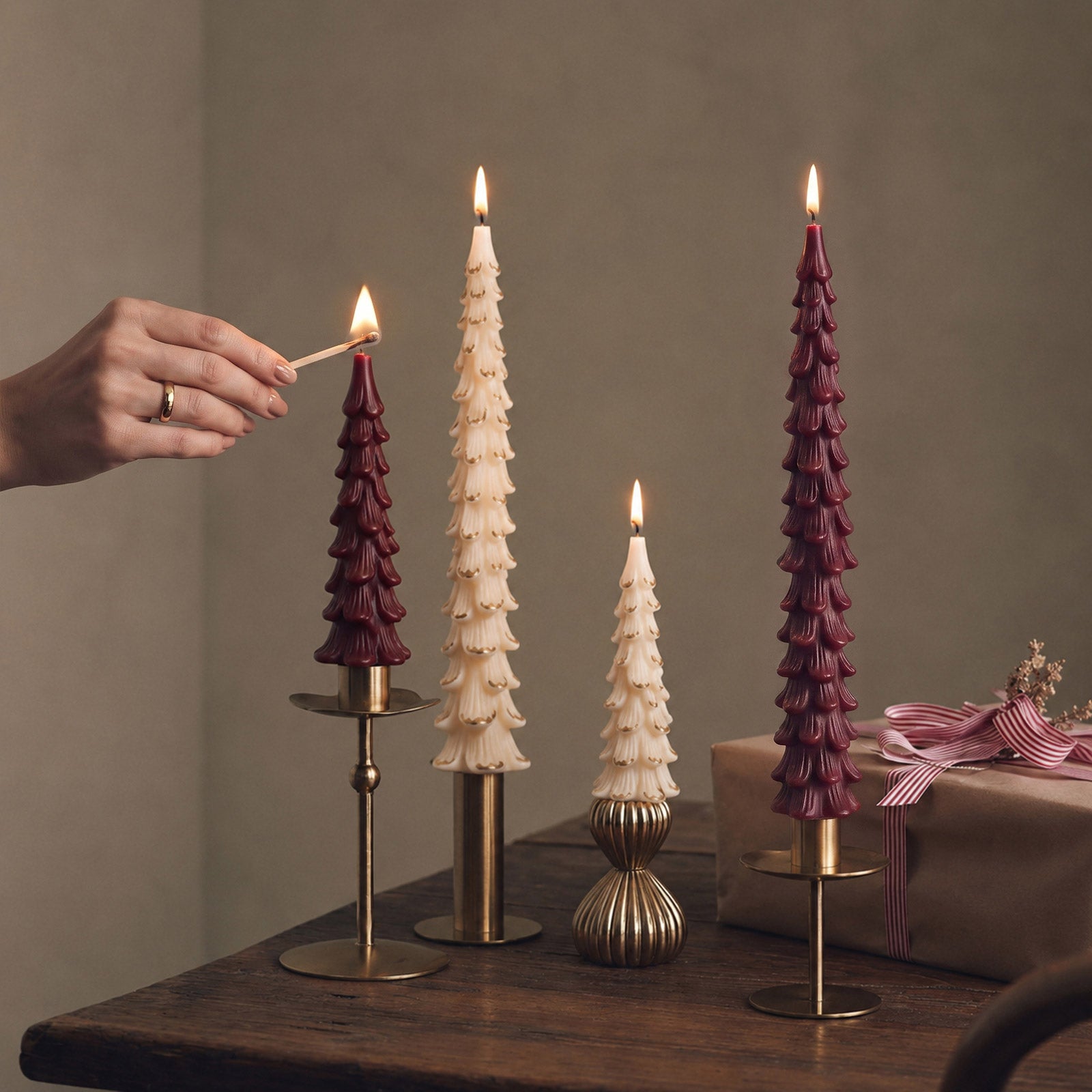 Lighting assorted colored winter pine taper candles placed on vintage brass candle holders - Boowan Nicole