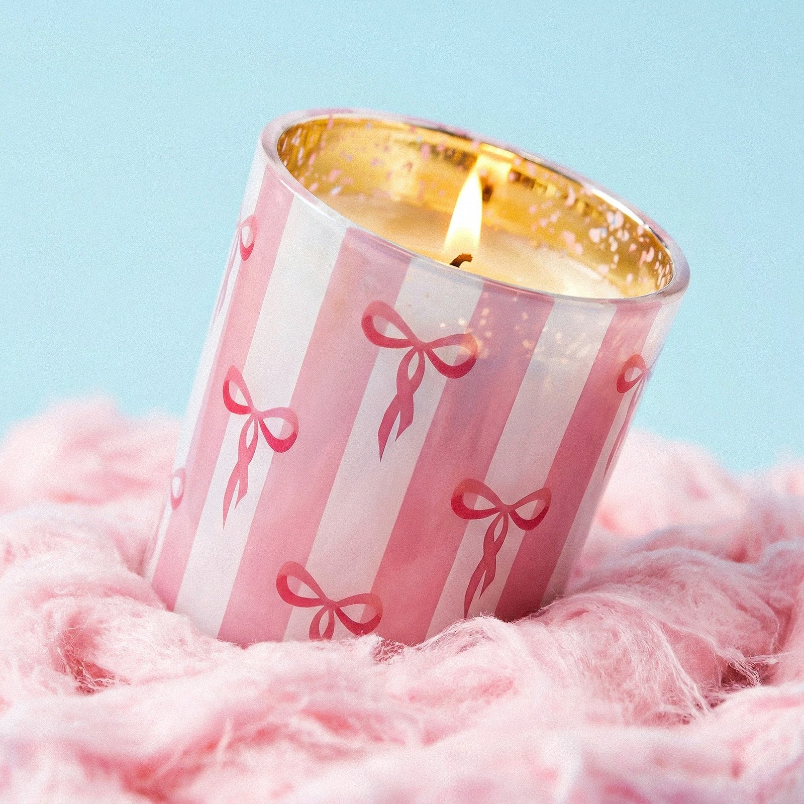 Lit Coquette Bow Striped Glass Candle Jar Rested on Fluffy Pink Faux Fur Fabric - Boowan Nicole