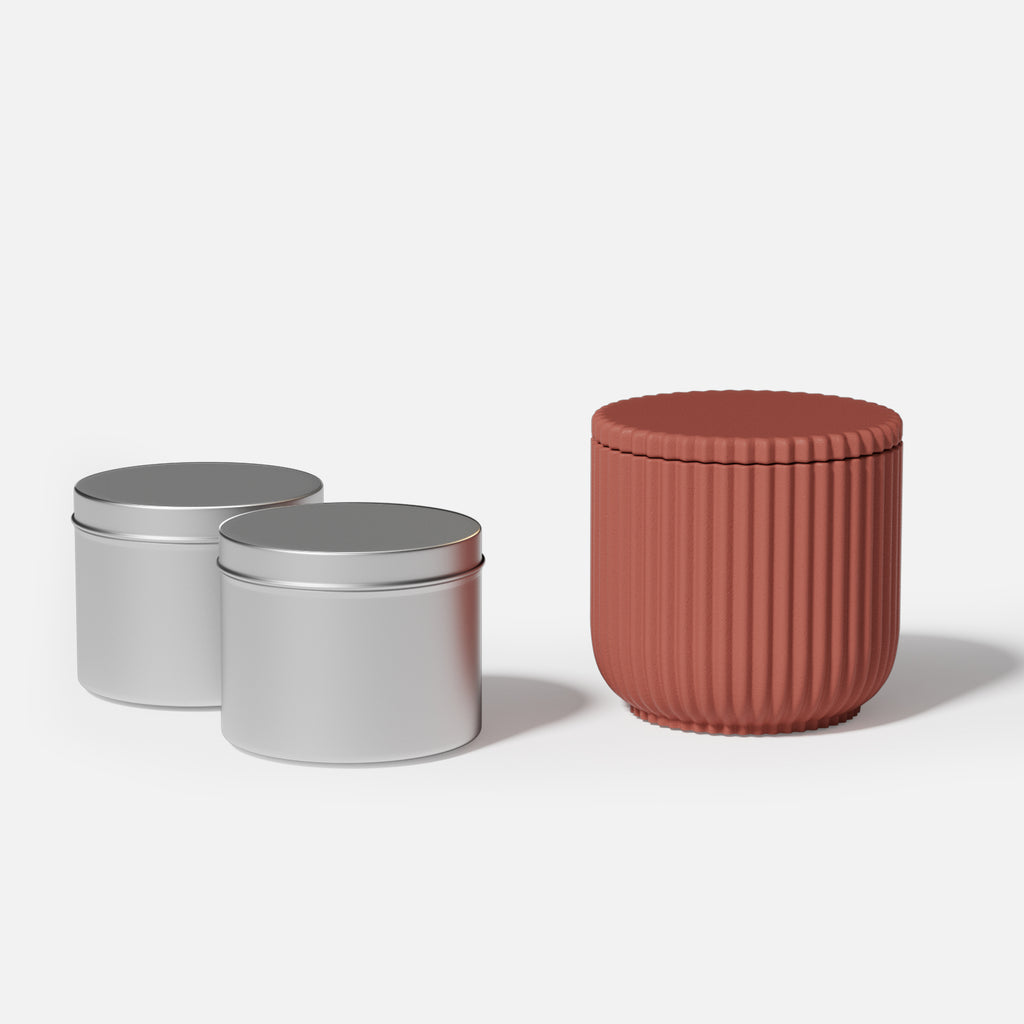 A reddish-brown ridged flat-lid candle jar made from a silicone mold produced by BooowanNicole and two aluminum jars for making refillable candles.