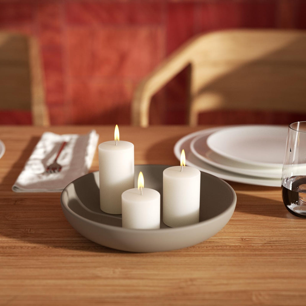 Lighted candles are placed in trays made using silicone molds.