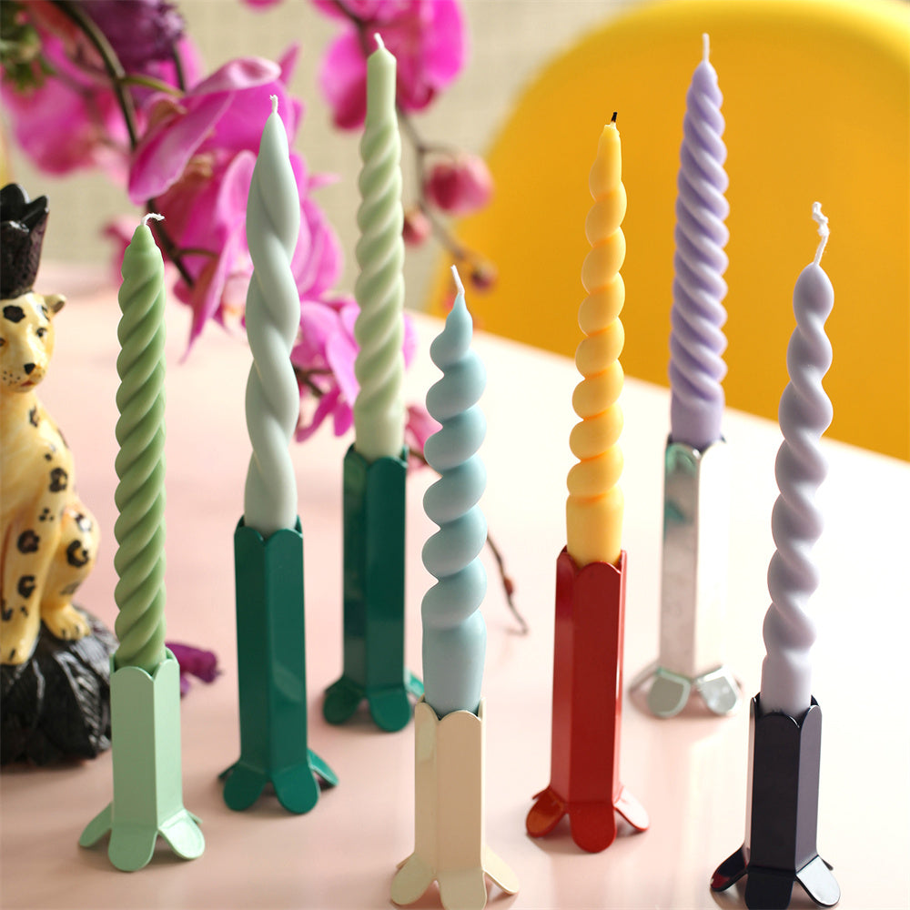 A variety of Boowannicole branded tapered candles crafted with silicone molds, each featuring unique shapes and colors, gracefully arranged on candle holders. Showcasing the brand's diverse creativity, these candles enhance the aesthetic of tabletop displays. 