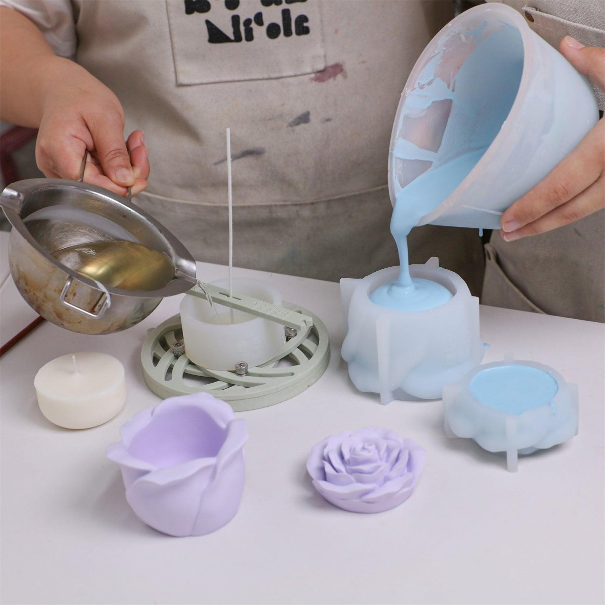 Pouring wax and pigment mixture into a rose-shaped silicone mold with support shell - Boowan Nicole