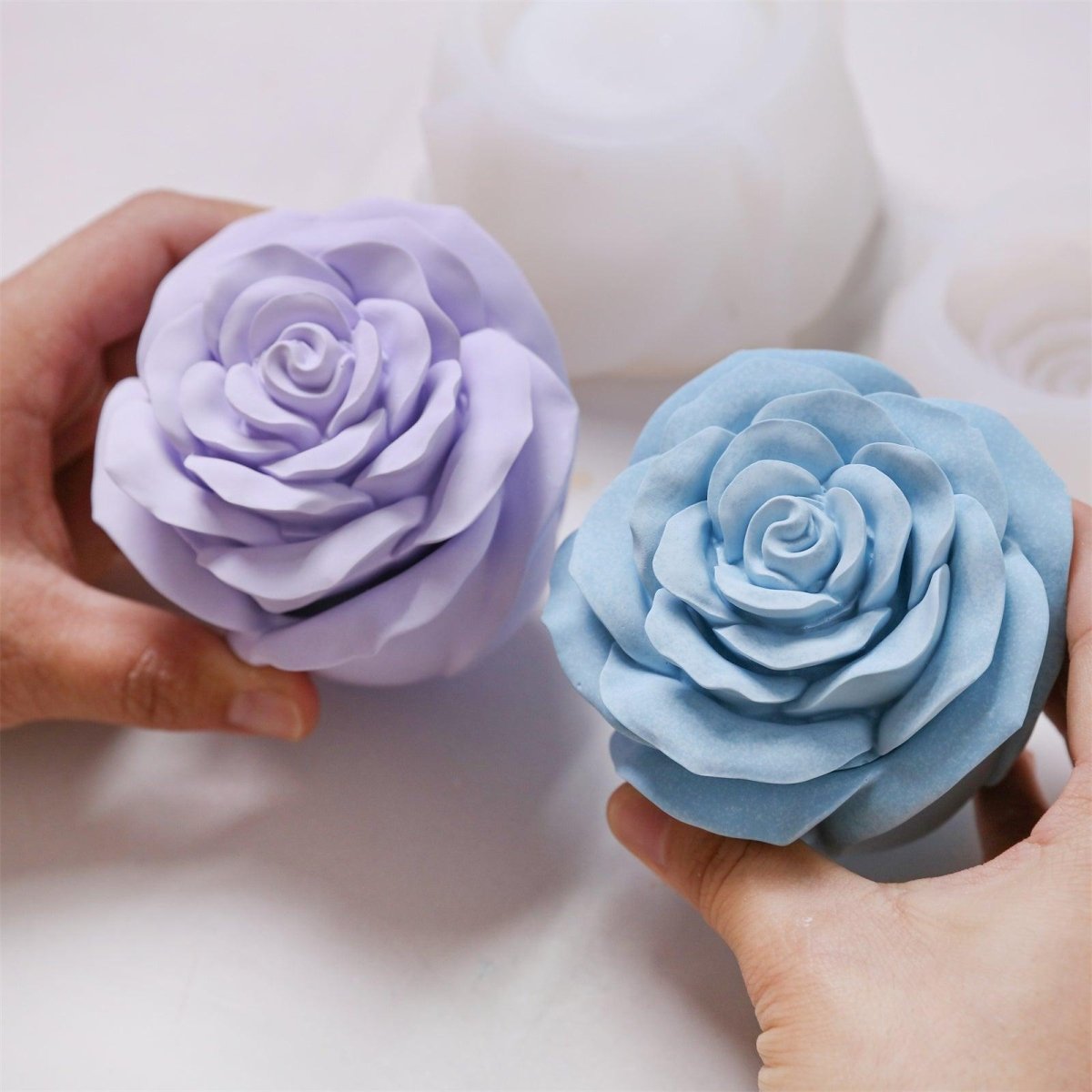 Two finished rose-shaped candle jars in pastel purple and blue, showcasing detailed petal textures and smooth matte surface - Boowan Nicole