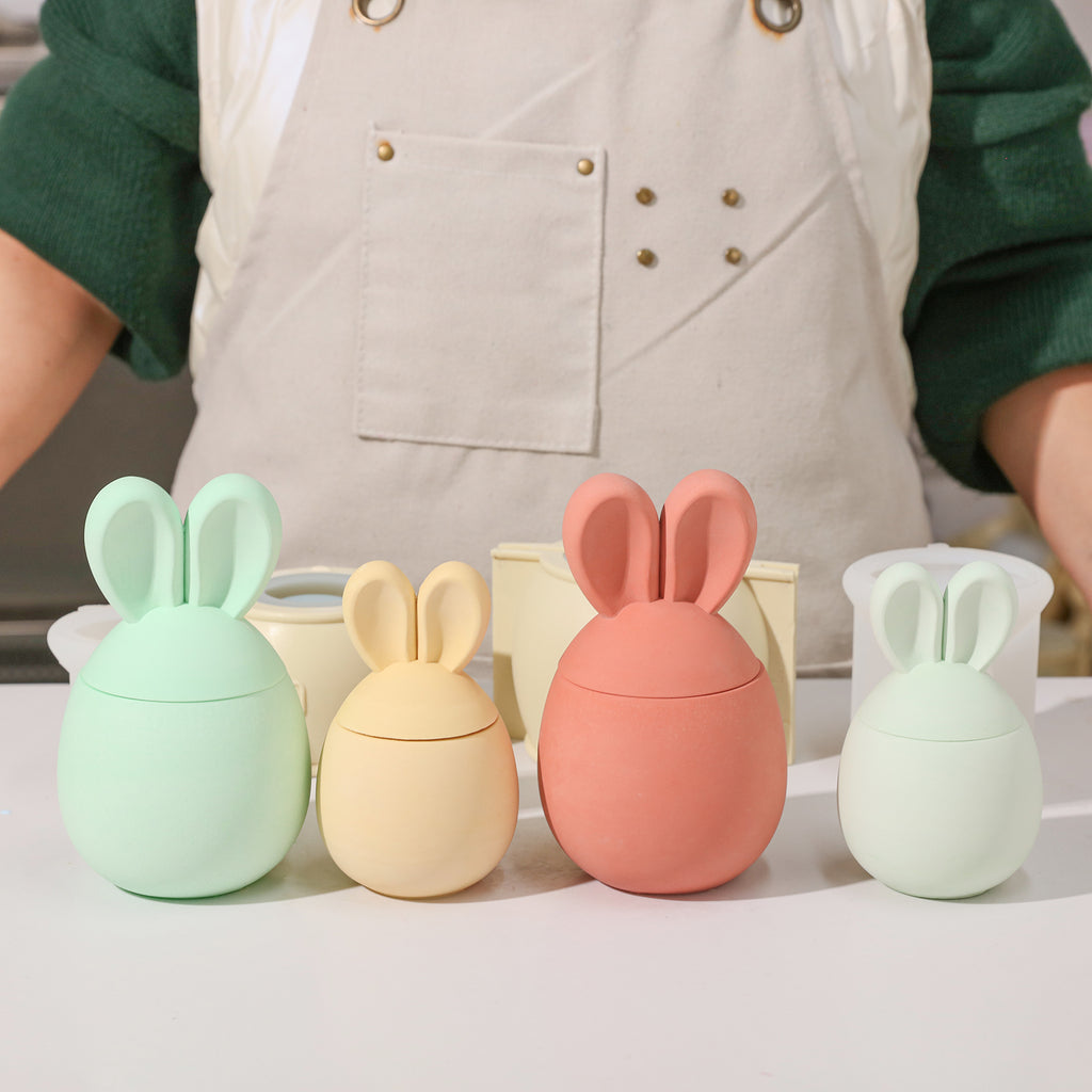 Four two large and two small Easter bunny candle jars in different colors