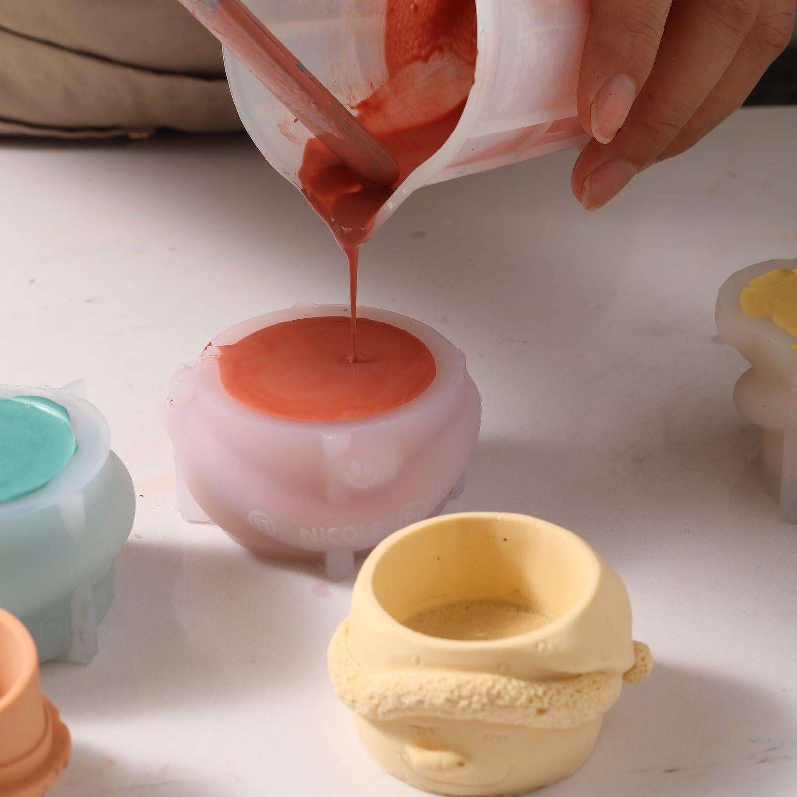 Pour Boowannite material into silicone molds to make Christmas snowman tea light candle holders - Boowan Nicole