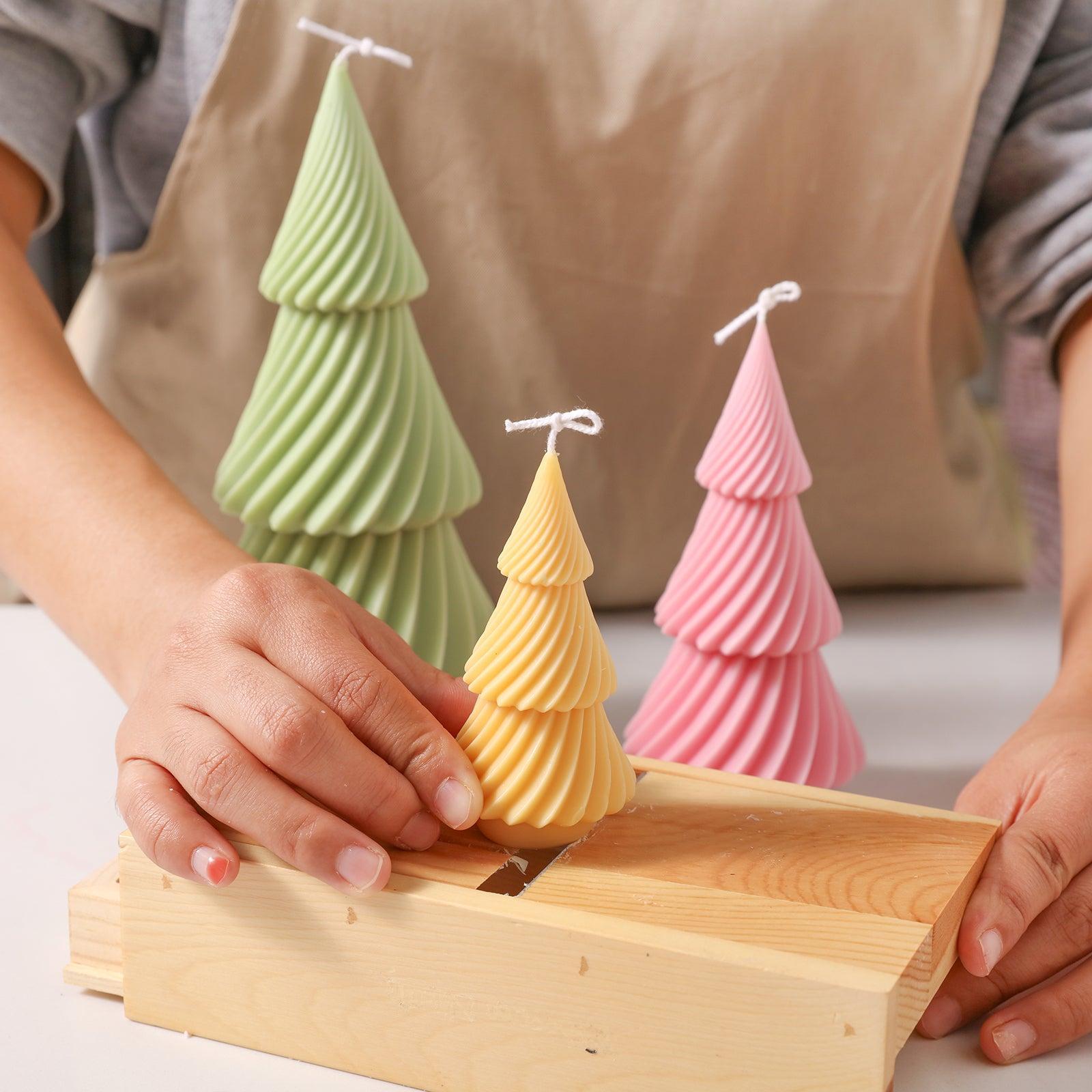 Use a tool to smooth the bottom of a yellow evergreen Christmas tree candle - Boowan Nicole