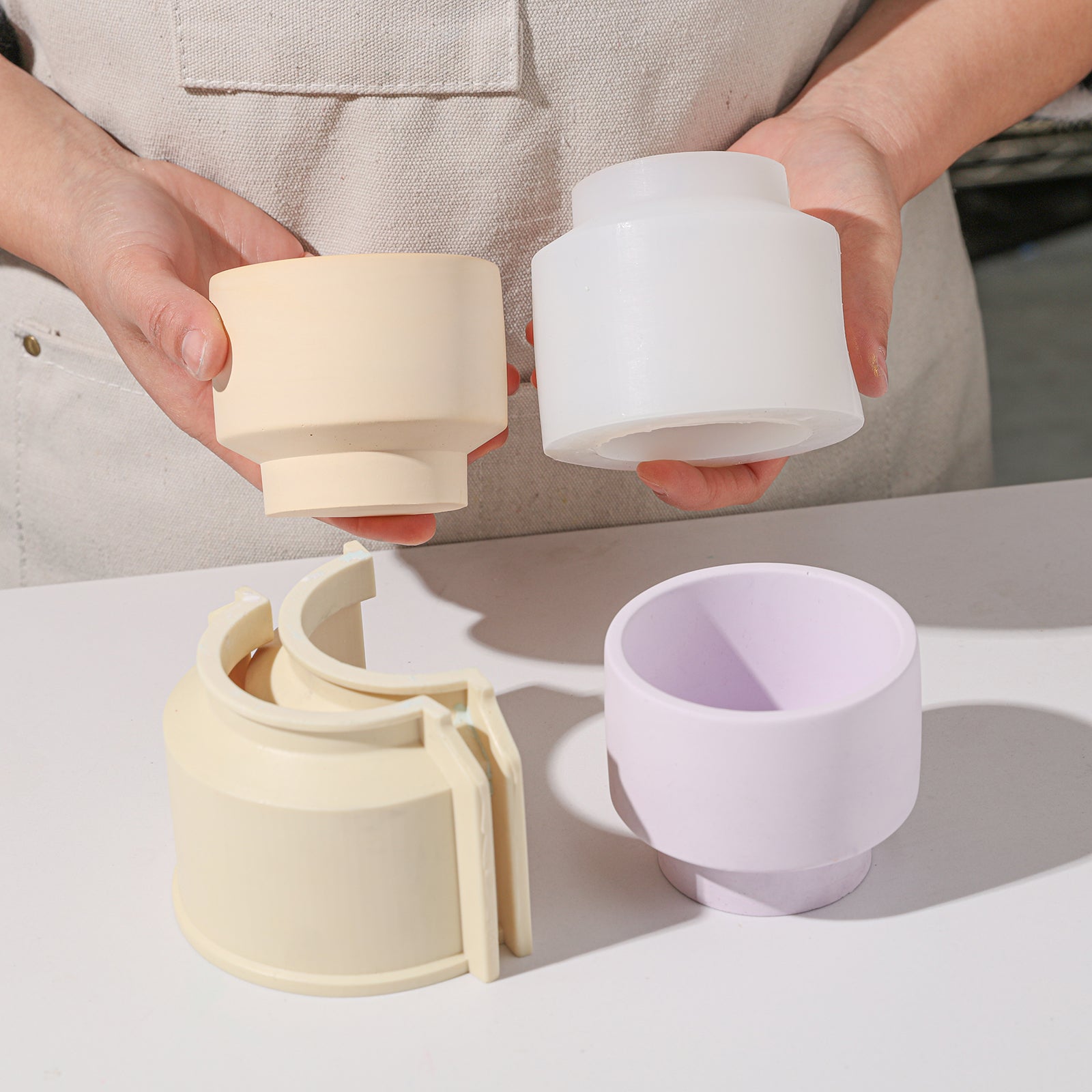 Holding yellow boowannicole candle jar and silicone mold, starting a creative journey in candle making.