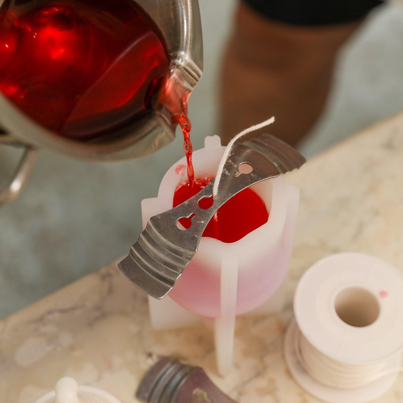 Pour the red wax solution into the white silicone mold to create Douglas of Hat-tastic Gnome Squad Candle-Boowan Nicole