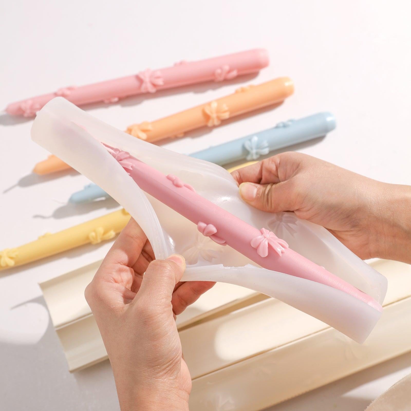 Witness the seamless release of a taper candle from the Ribbon Bow Taper Candle Silicone Mold.