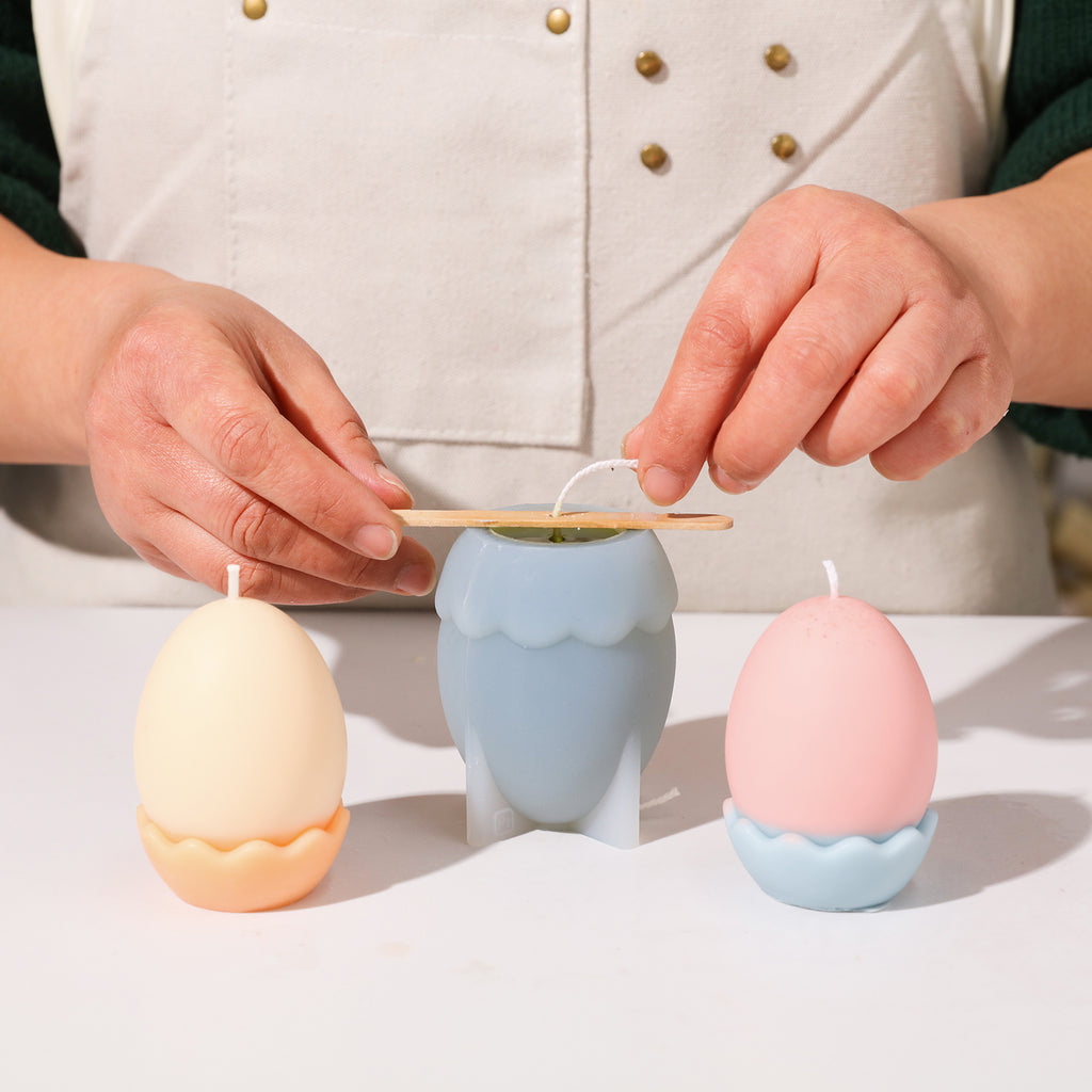 Pouring wax into the mold to create Easter eggs with eggshell candles.