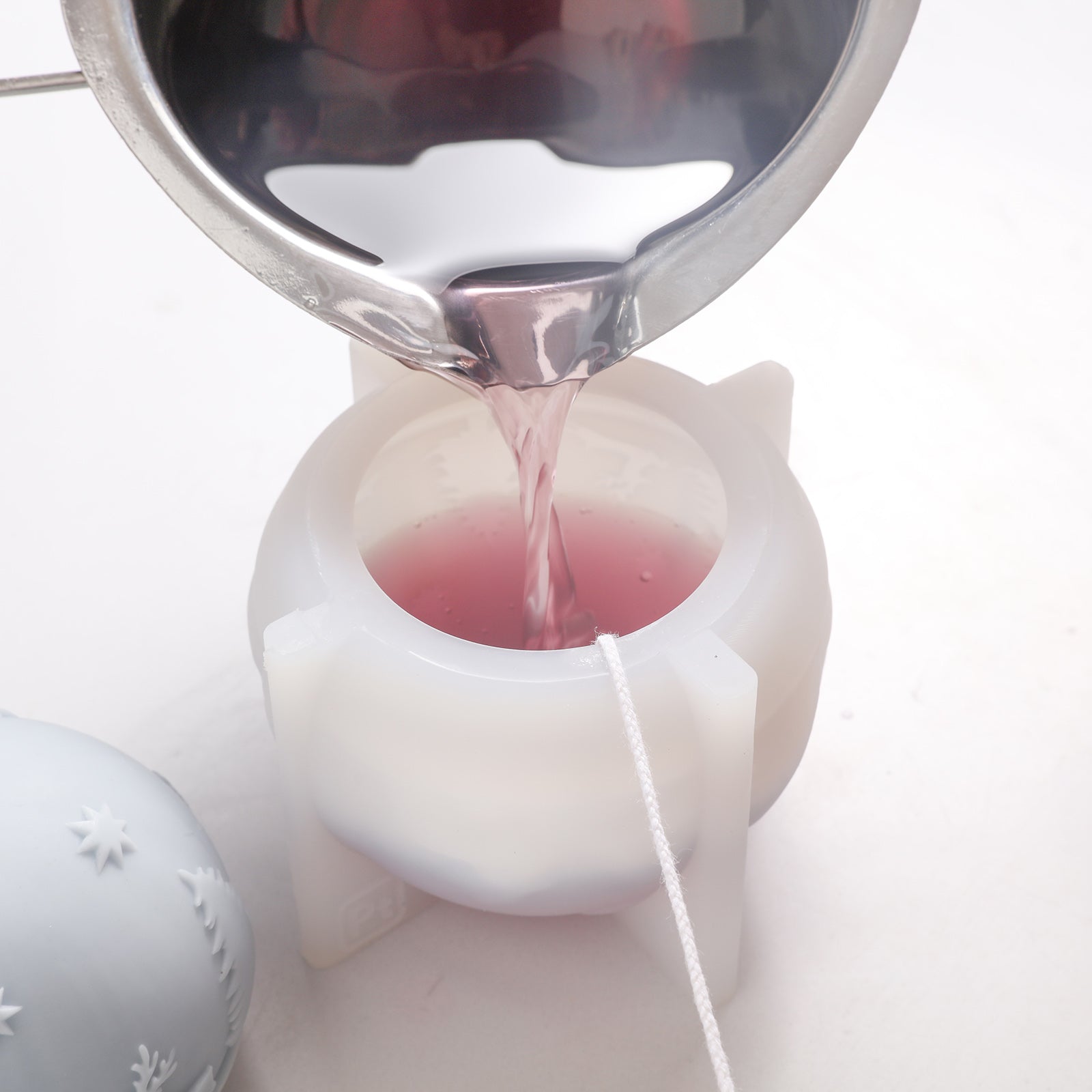 Purple wax liquid poured into silicone molds by Boowan Nicole