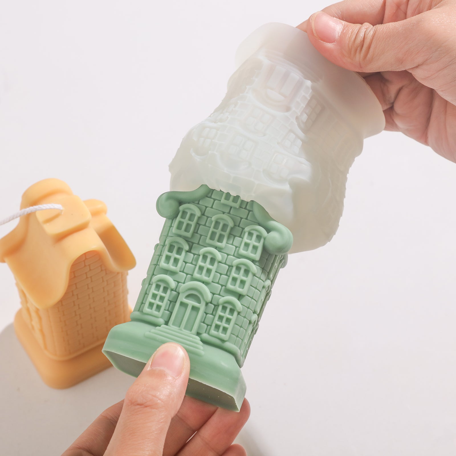 Nine window house candles emerge from silicone molds.