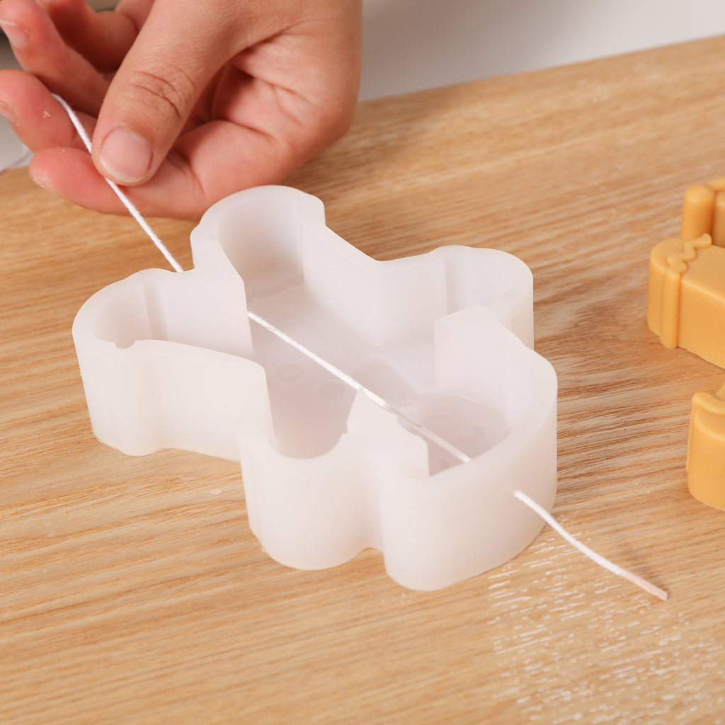 Threading candle wicks in white silicone molds for making Gingerbread Baby candles - Boowan Nicole
