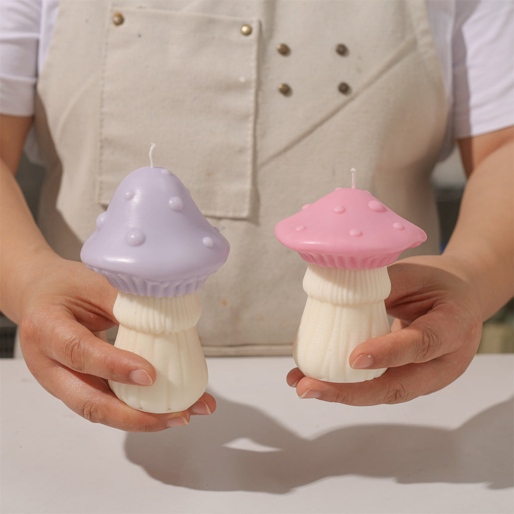 Holding and displaying a color-blocked purple and pink mushroom candle.