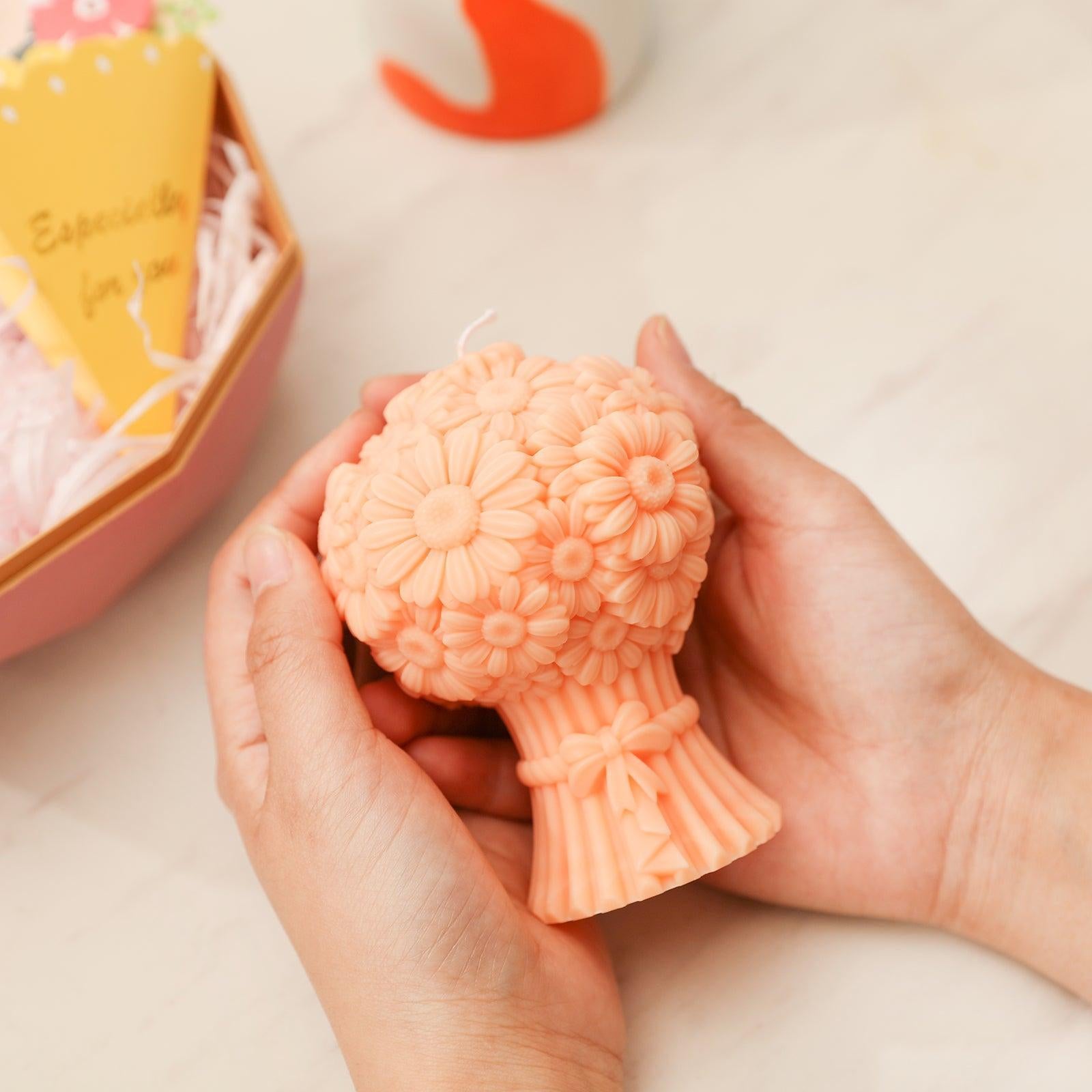 Hands holding orange Daisy Bouquet Flourishing Candle - Boowan Nicole