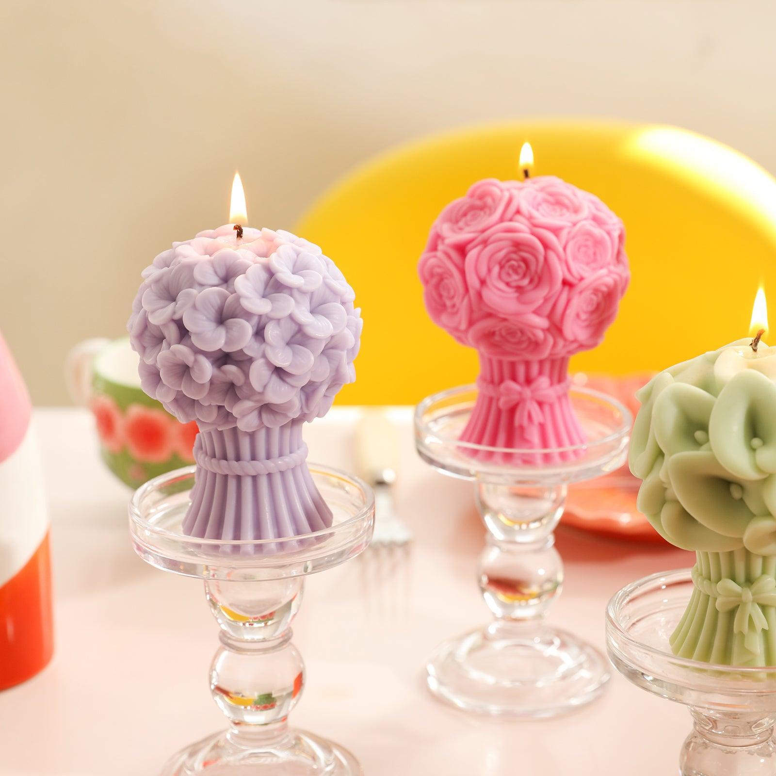 A pink Hydrangea Bouquet Flourishing Candle is burning in a crystal tray on the table next to a rose and calla lily bouquet candle - Boowan Nicole