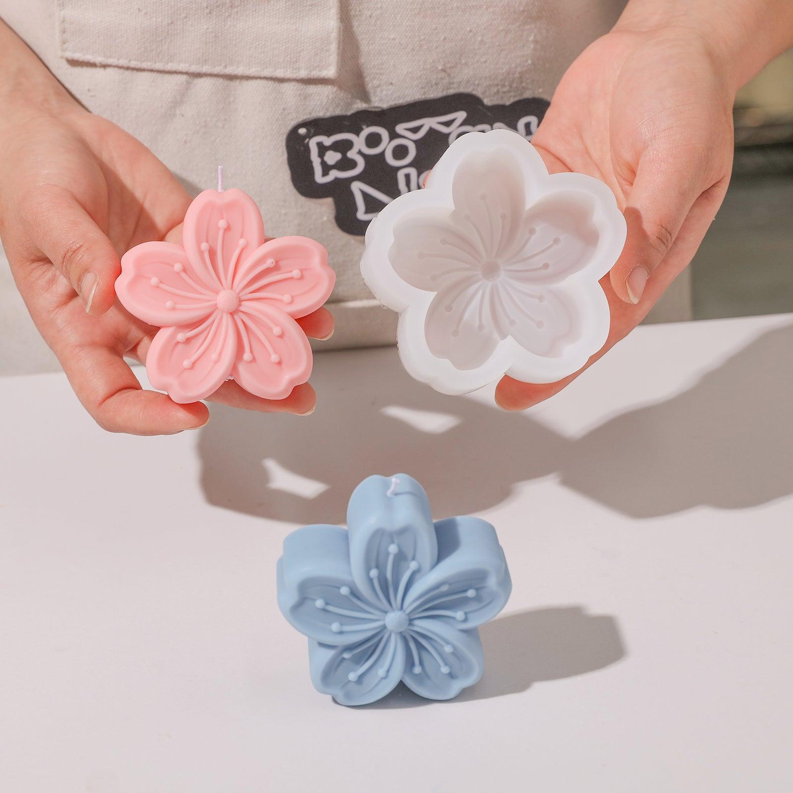 Hand-held display of pink Sakura Candle and white silicone mold-Boowan Nicole