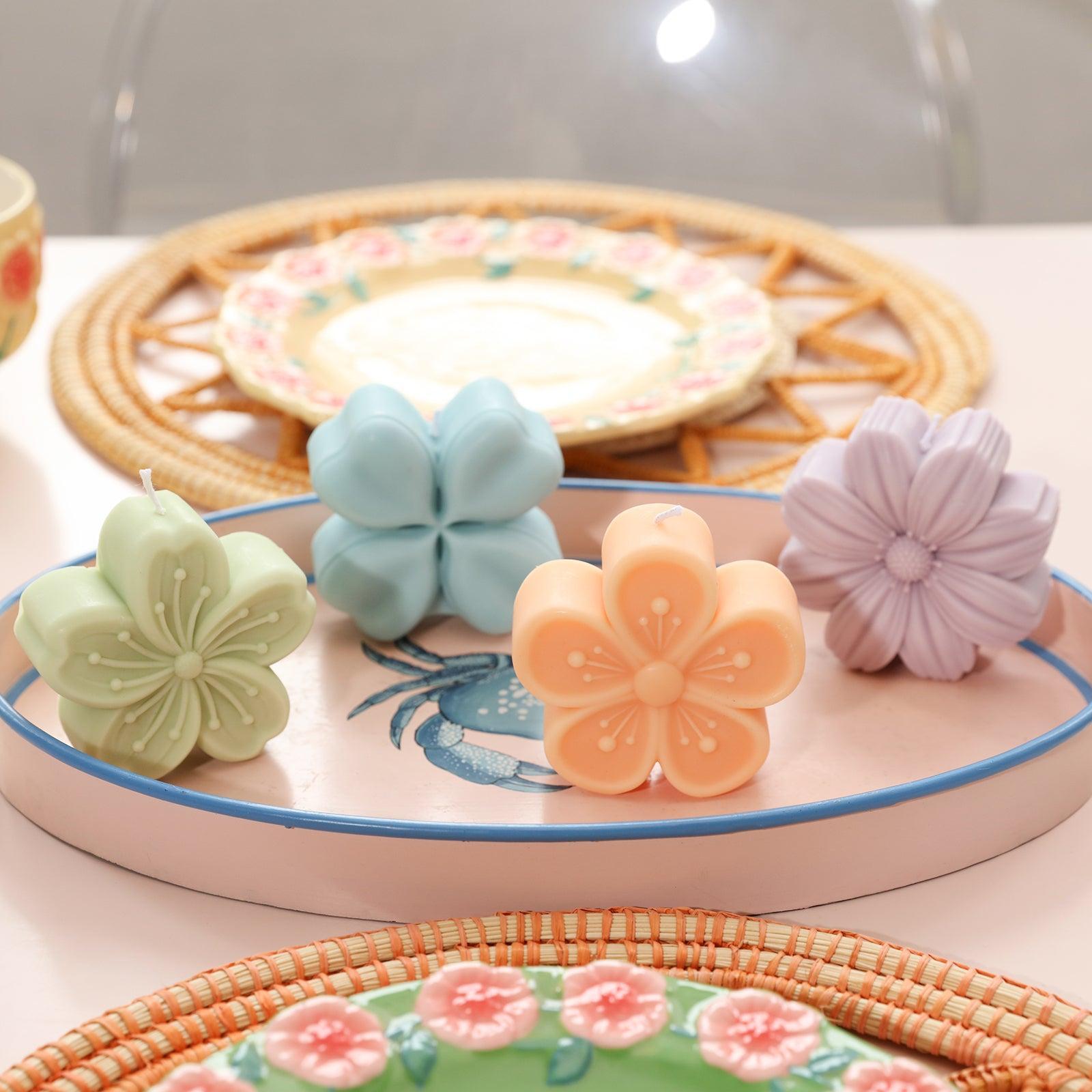 Four different shapes of green, blue, pink and purple Peach Blossom Candle-Boowan Nicole on the dining table tray