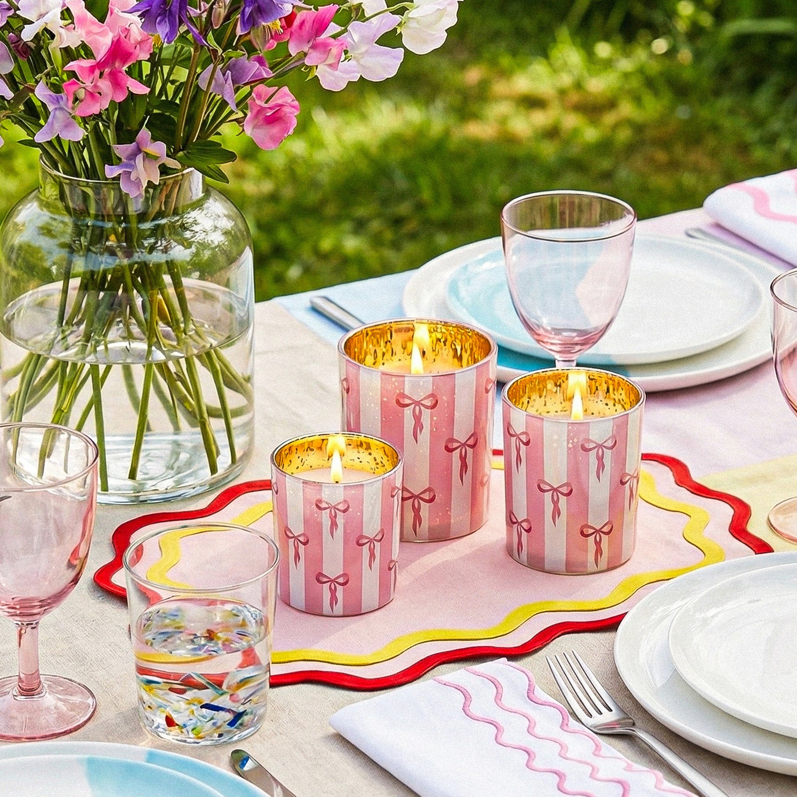 Three Burning Cute Bow Stripe Candle Cups Arranged on Outdoor Dining Table With Fresh Florals and Tableware - Boowan Nicole