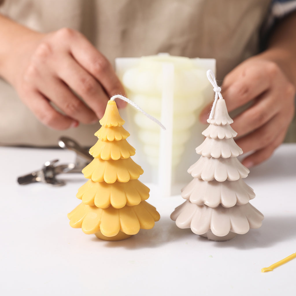 Yellow, gray and white Christmas tree candles come out of silicone molds and are placed on the table, designed by Boowan Nicole.