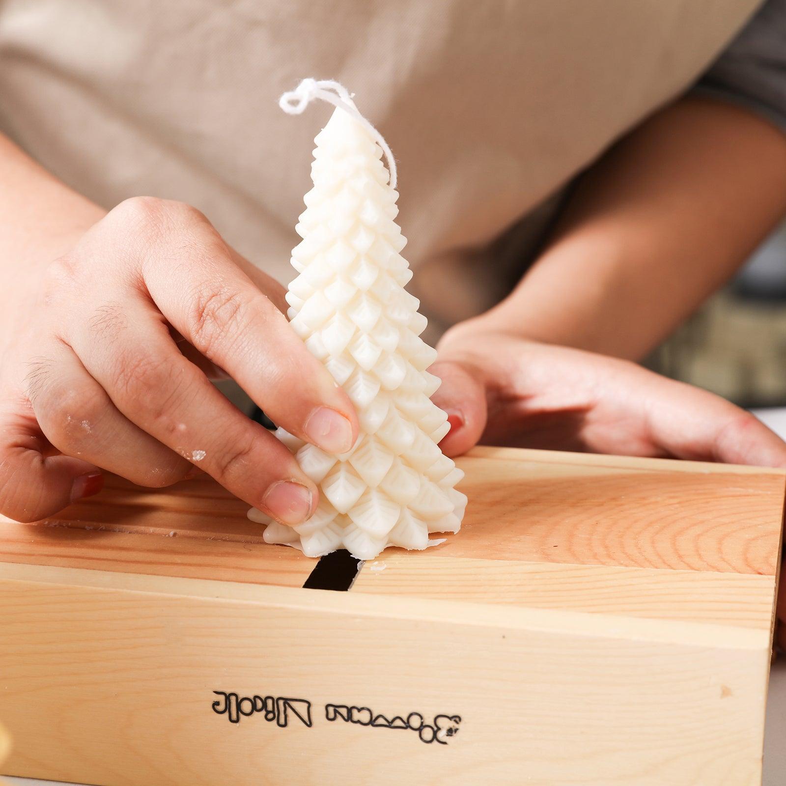 Use a tool to smooth the bottom of a white Christmas pine candle - Boowan Nicole