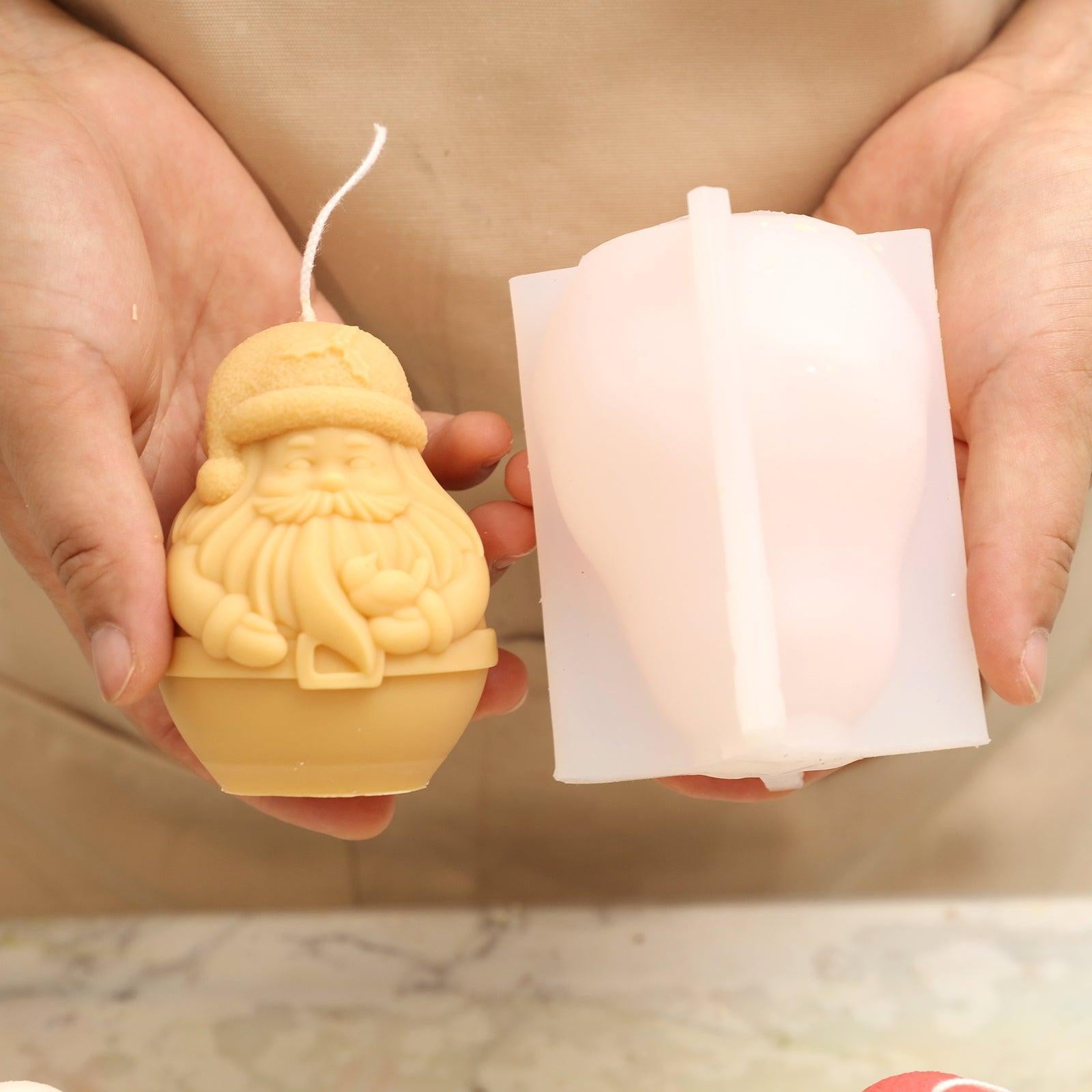 Handheld display of white silicone moulds and yellow Santa Claus Candle-Boowan Nicole