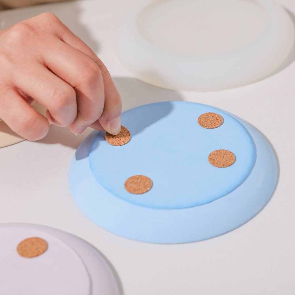 Applying non-slip pads to the back of the round trays.