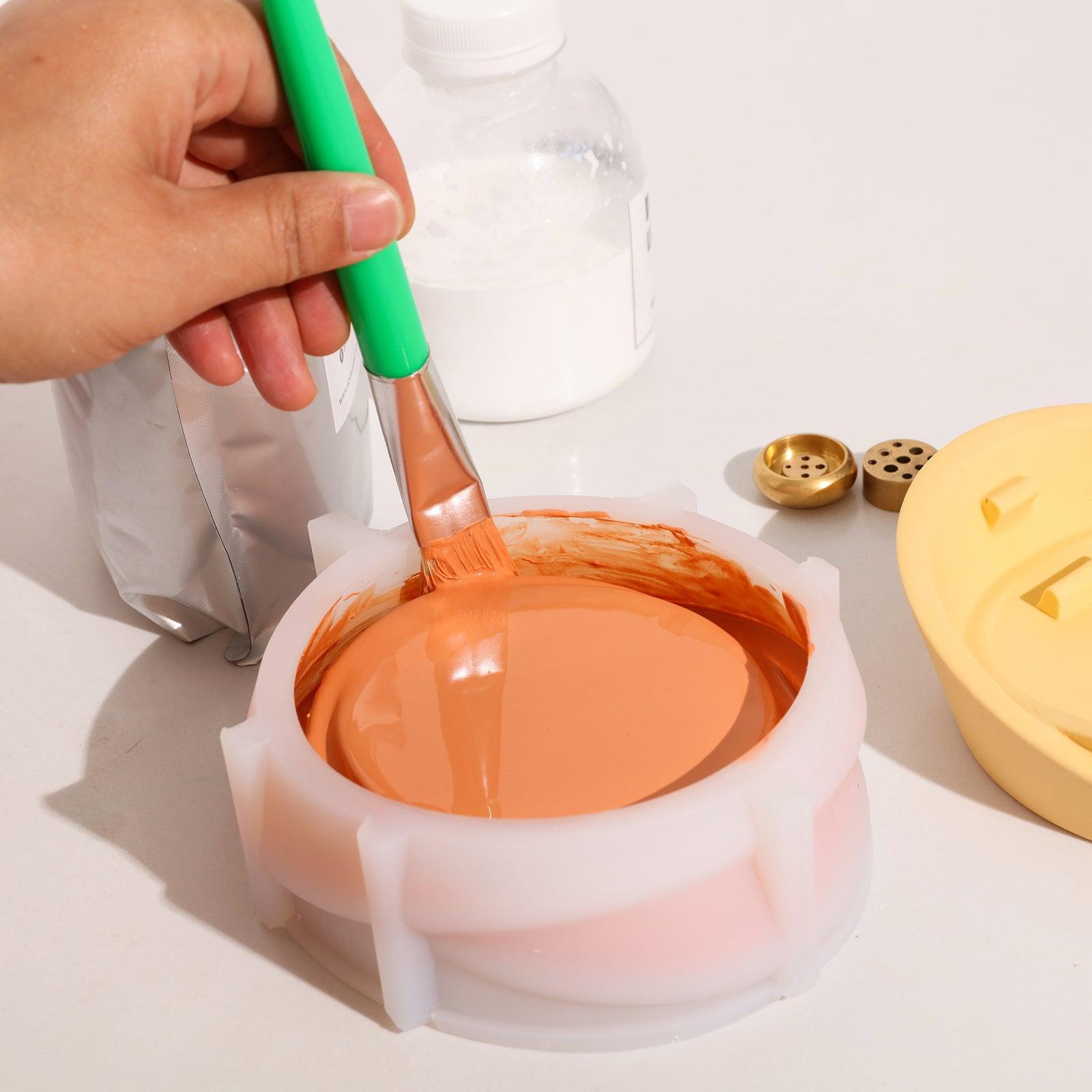 Use a brush to remove air bubbles from the boowannite material in the white silicone mold used to make the Sail-Shape Incense Holder -Boowan Nicole