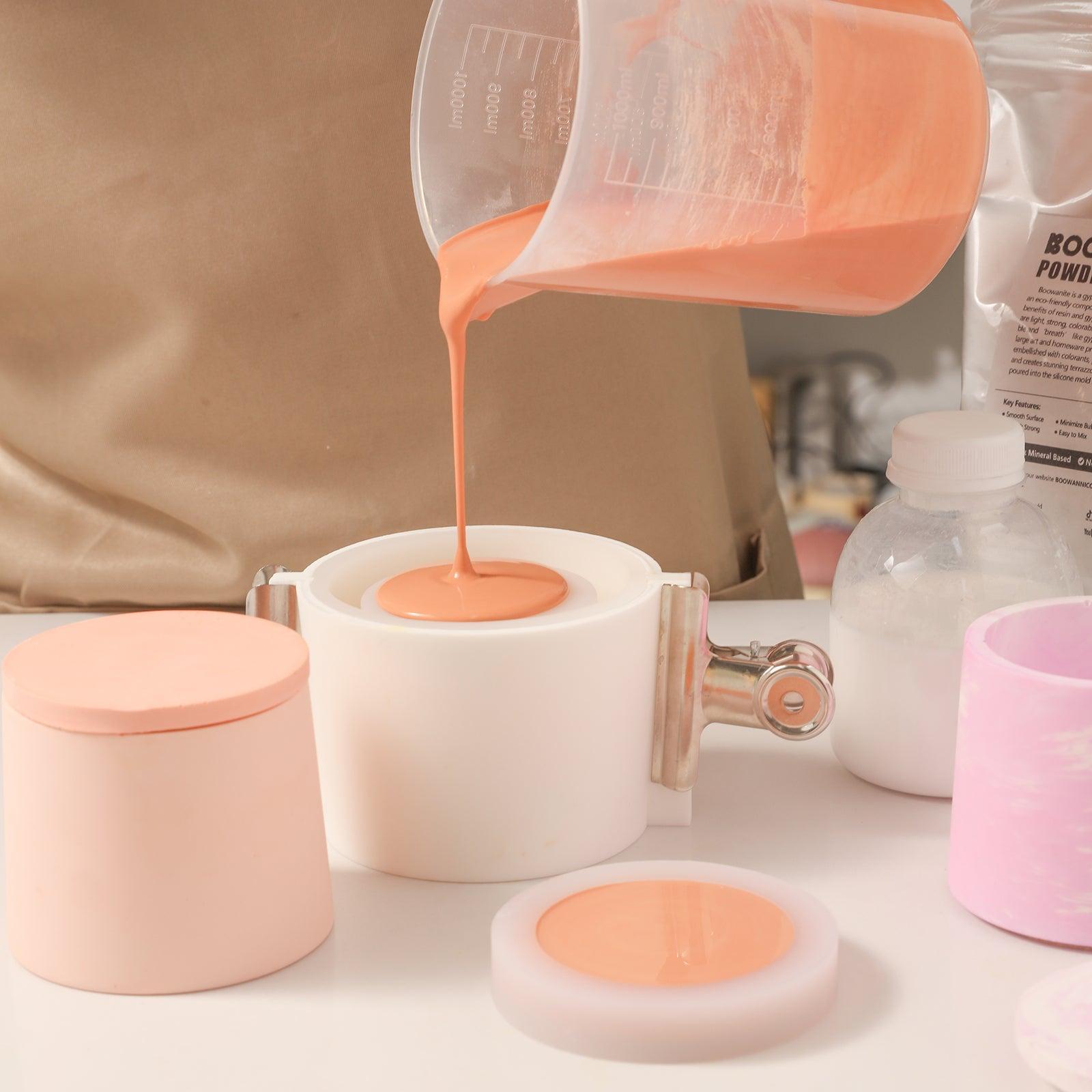 Pouring vibrant orange Boowannite material into a silicone mold for crafting candle jar bodies with Boowannicole's artistry.