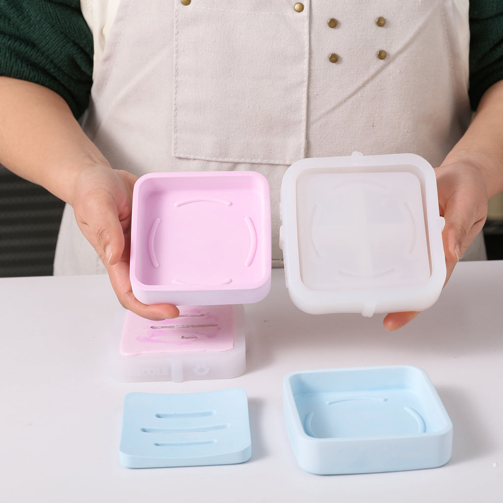 Holding a pink soap box and silicone mold in hand, showcasing exquisite handmade soap production.