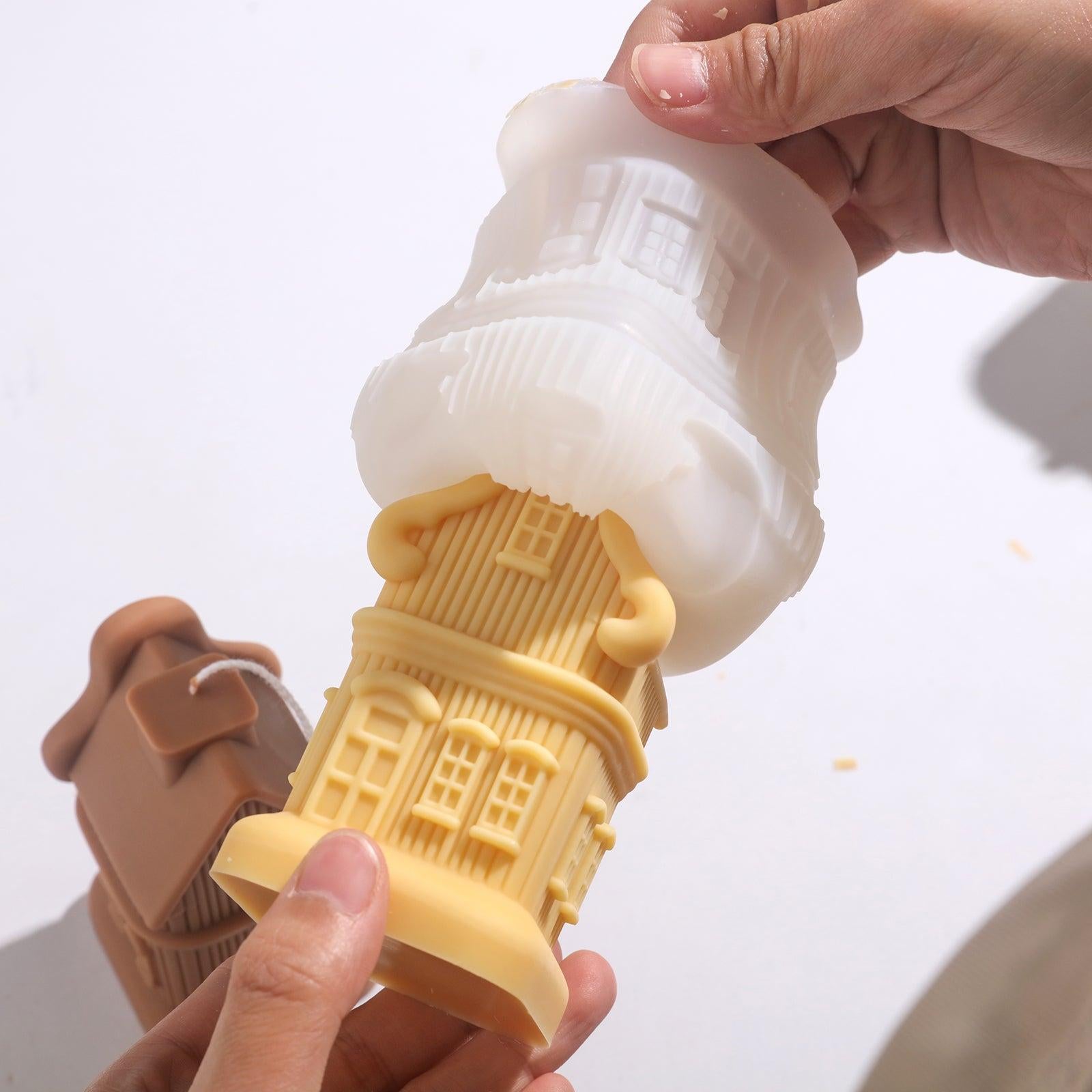 Yellow house candle emerges from silicone mold, showing design details, by Boowan Nicole.