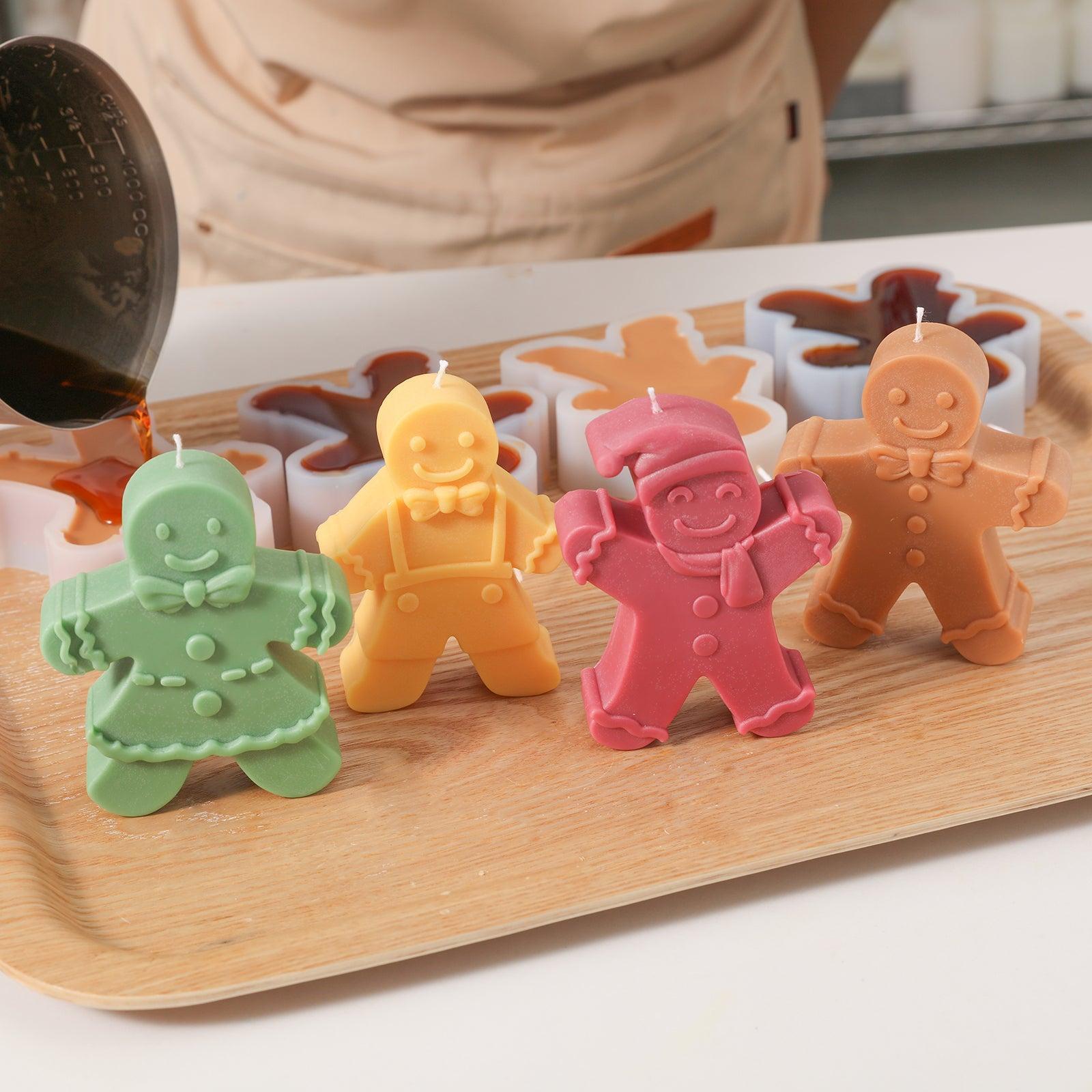 There are four different gingerbread man candles in green, yellow, red and brown styles in the tray, designed by Boowan Nciole.