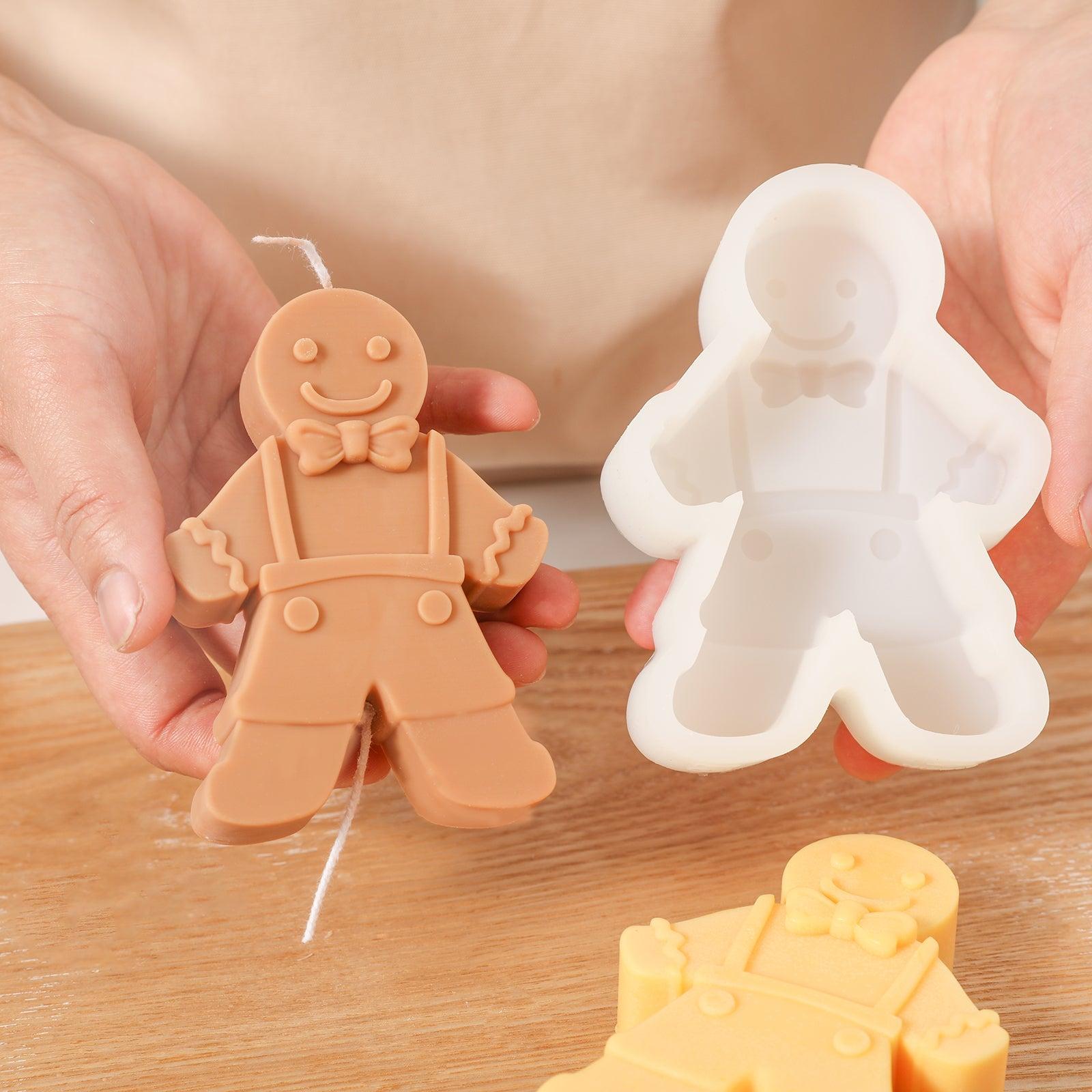 Hand-held display of brown Gingerbread Kid candle and white silicone mold-Boowan Nicole