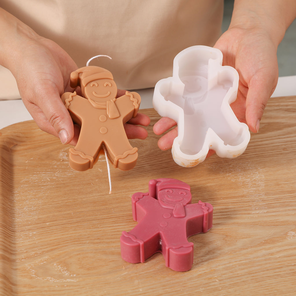 Hand-held display of brown Gingerbread Baby candle and white silicone mold-Boowan Nicole
